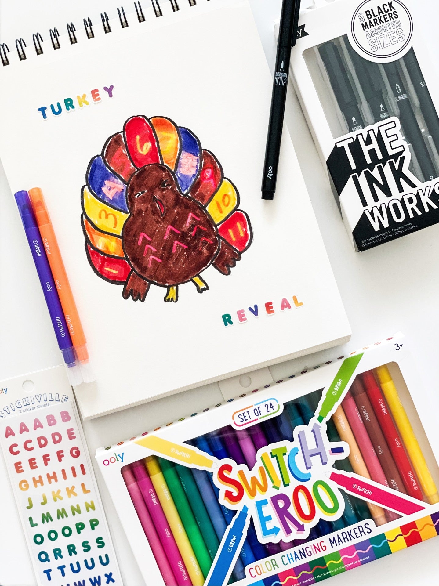 arts and crafts on table with markers, stickers, notepad and pens