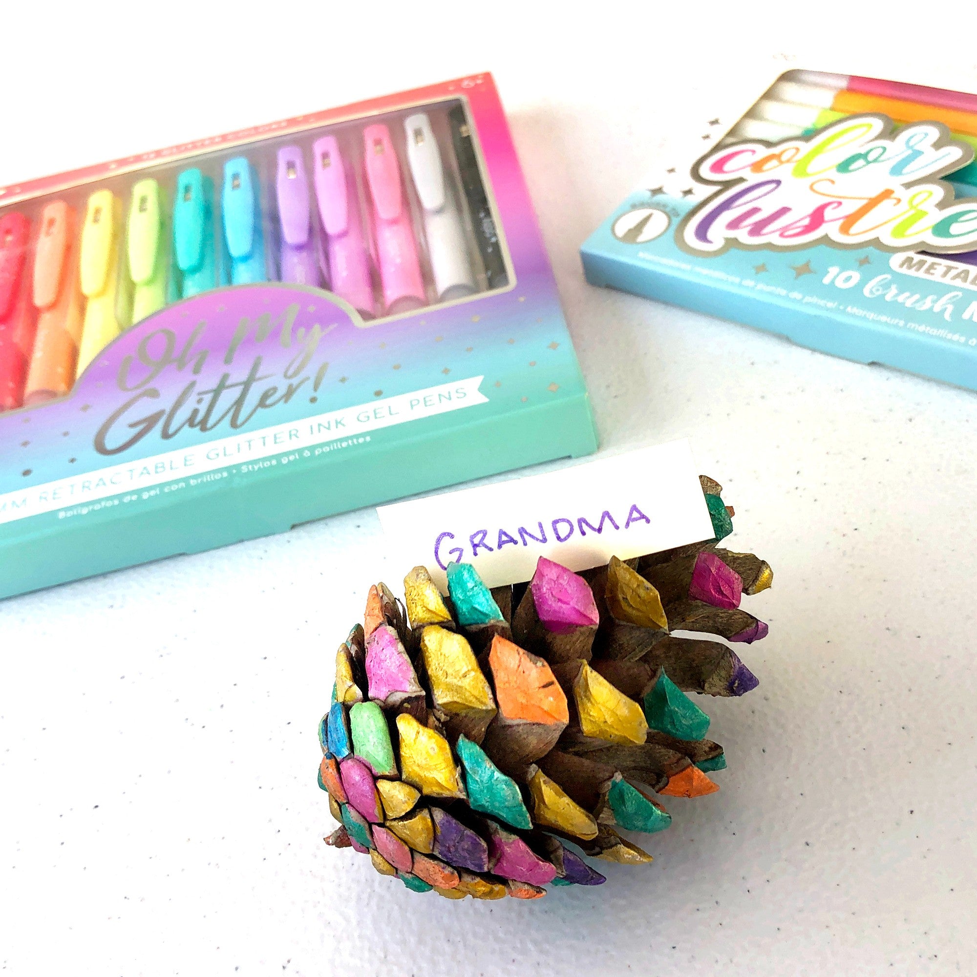 Colored pinecone placeholder for Grandma with markers and pens in the background