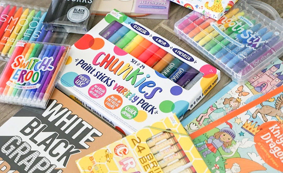 rainbow school supplies: markers, paint sticks, crayons, coloring books, black markers and paper