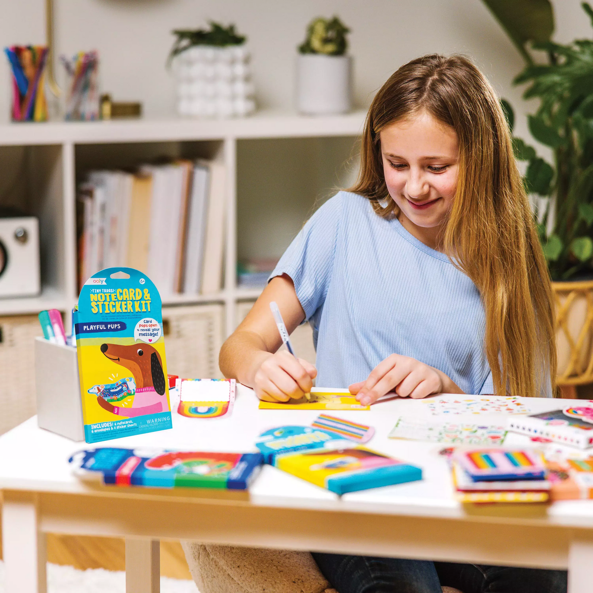 Girl writing in Tiny Tada! Playful Pups note card and sticker kit