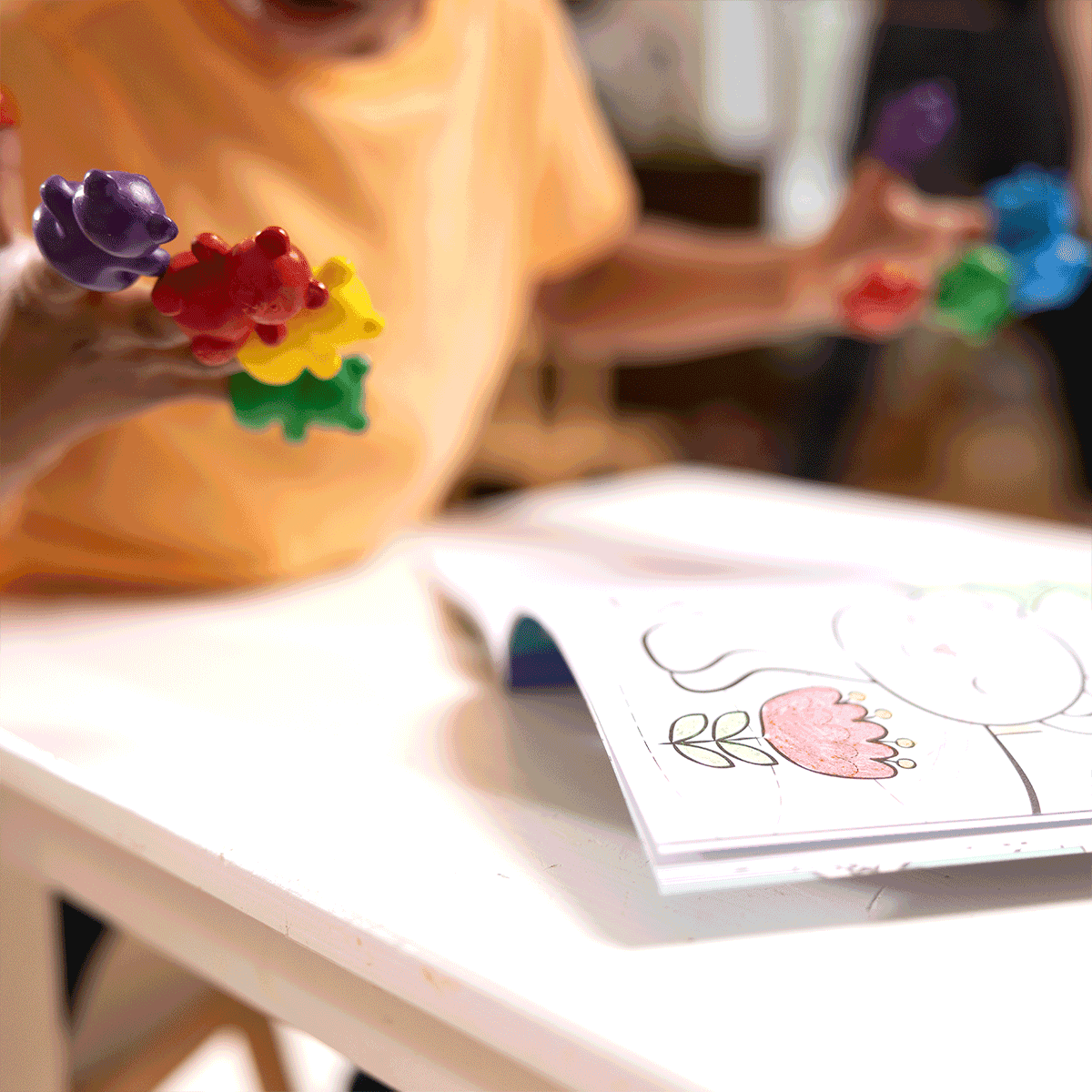 Kid with Cuddly Cubs bear finger crayons on fingers with coloring book