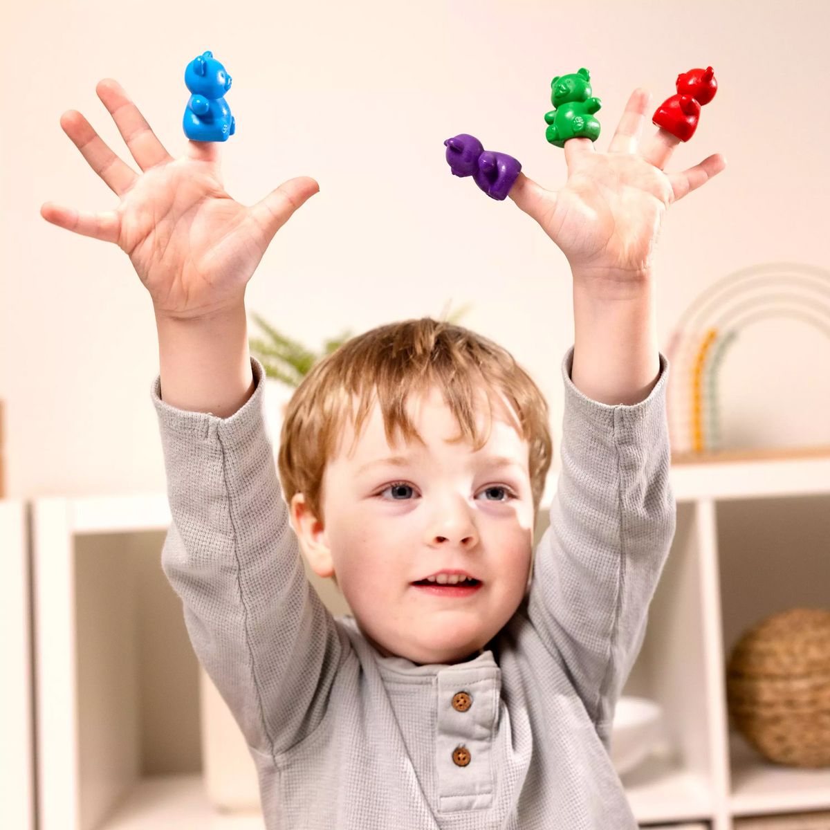 Child holding up hands with Cuddly Cubs bear finger crayons