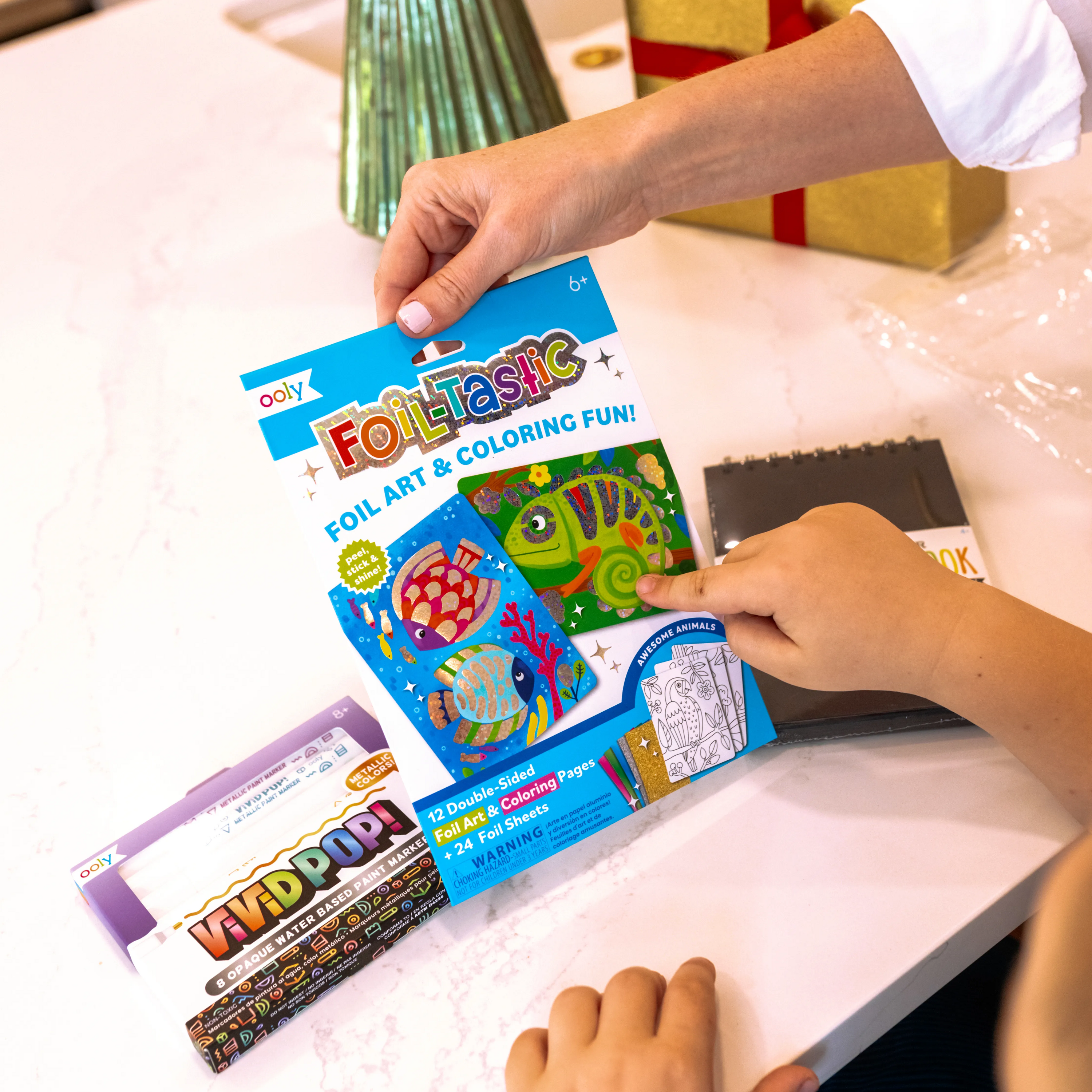 Mom holding up OOLY Foil-Tastic set from the Metallic Art Gift Pack