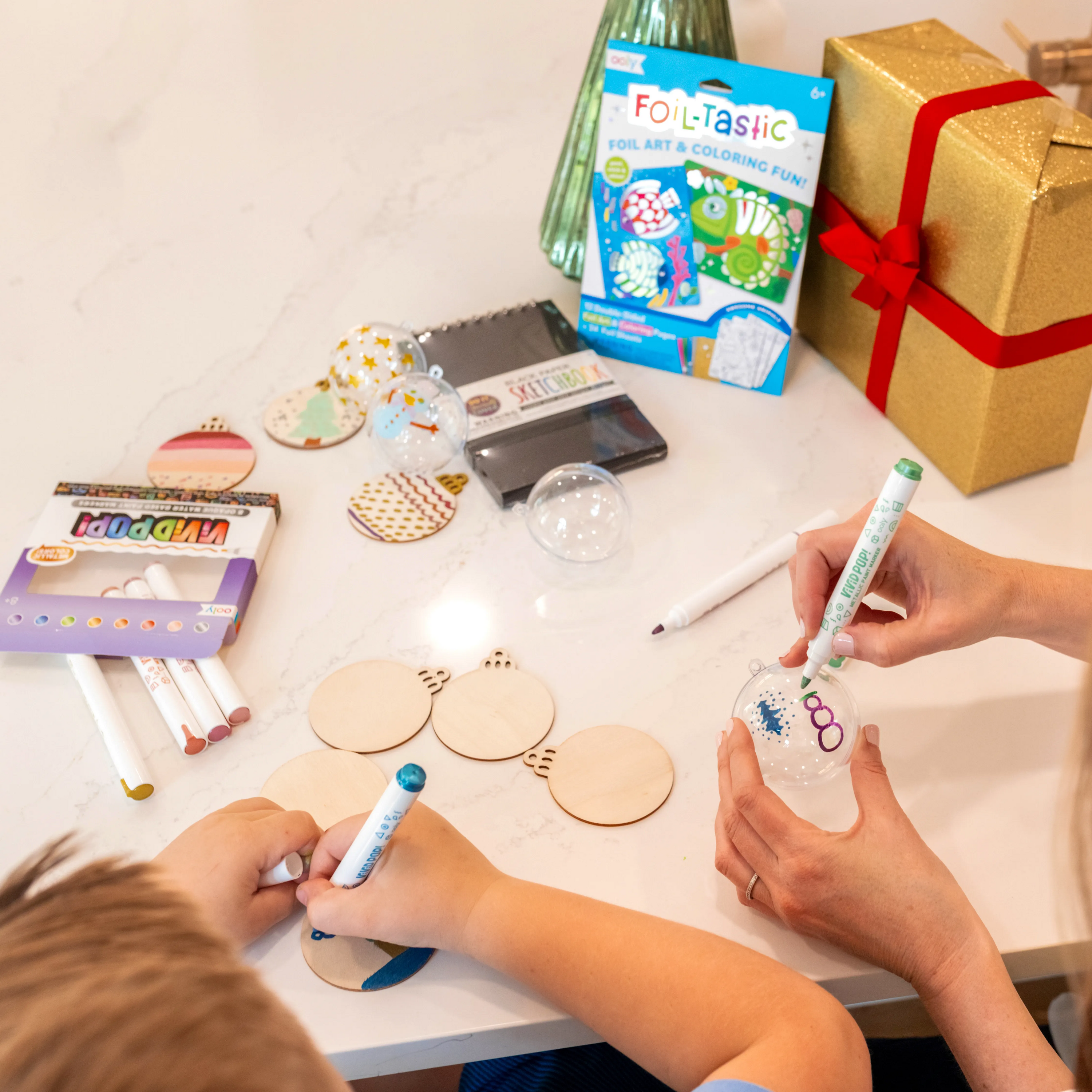 Kid and mom decorating holiday ornaments from a Metallic Art Gift Pack