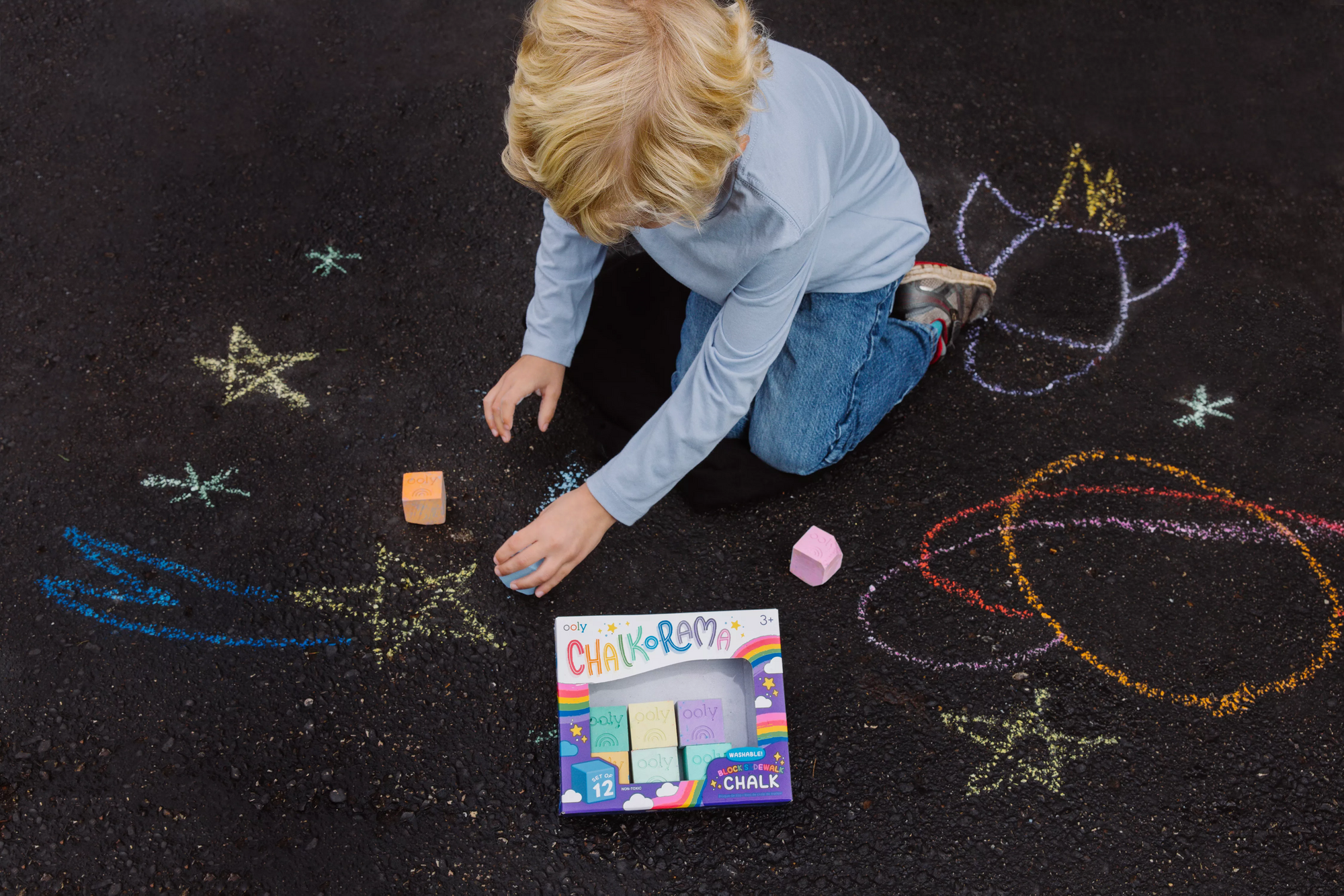 Child drawing space shapes with OOLY Chalk-O-Rama Block Sidewalk Chalk on blacktop