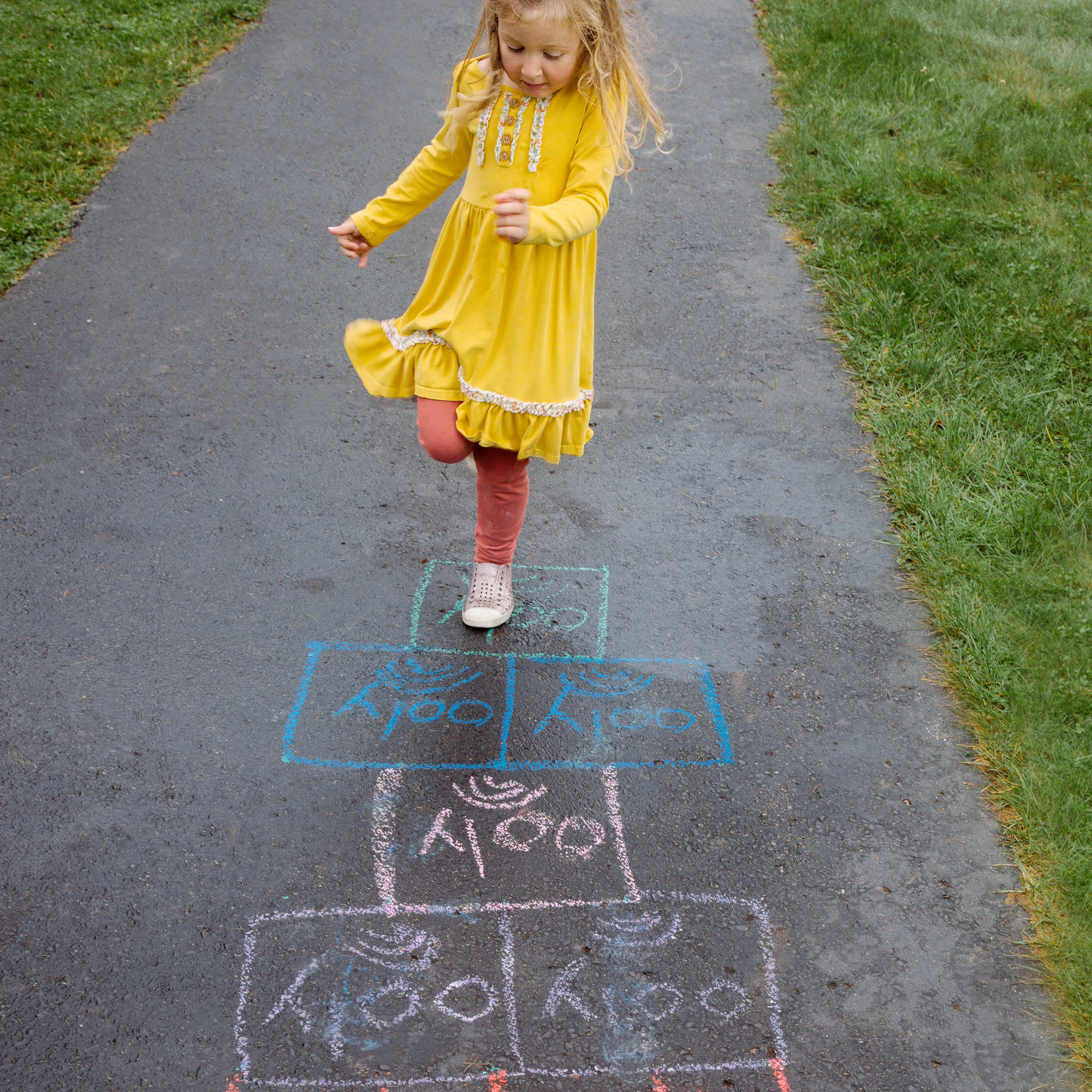 Girl skipping on hopscotch pattern mad with OOLY Chalk-O-Rama Block Sidewalk Chalk