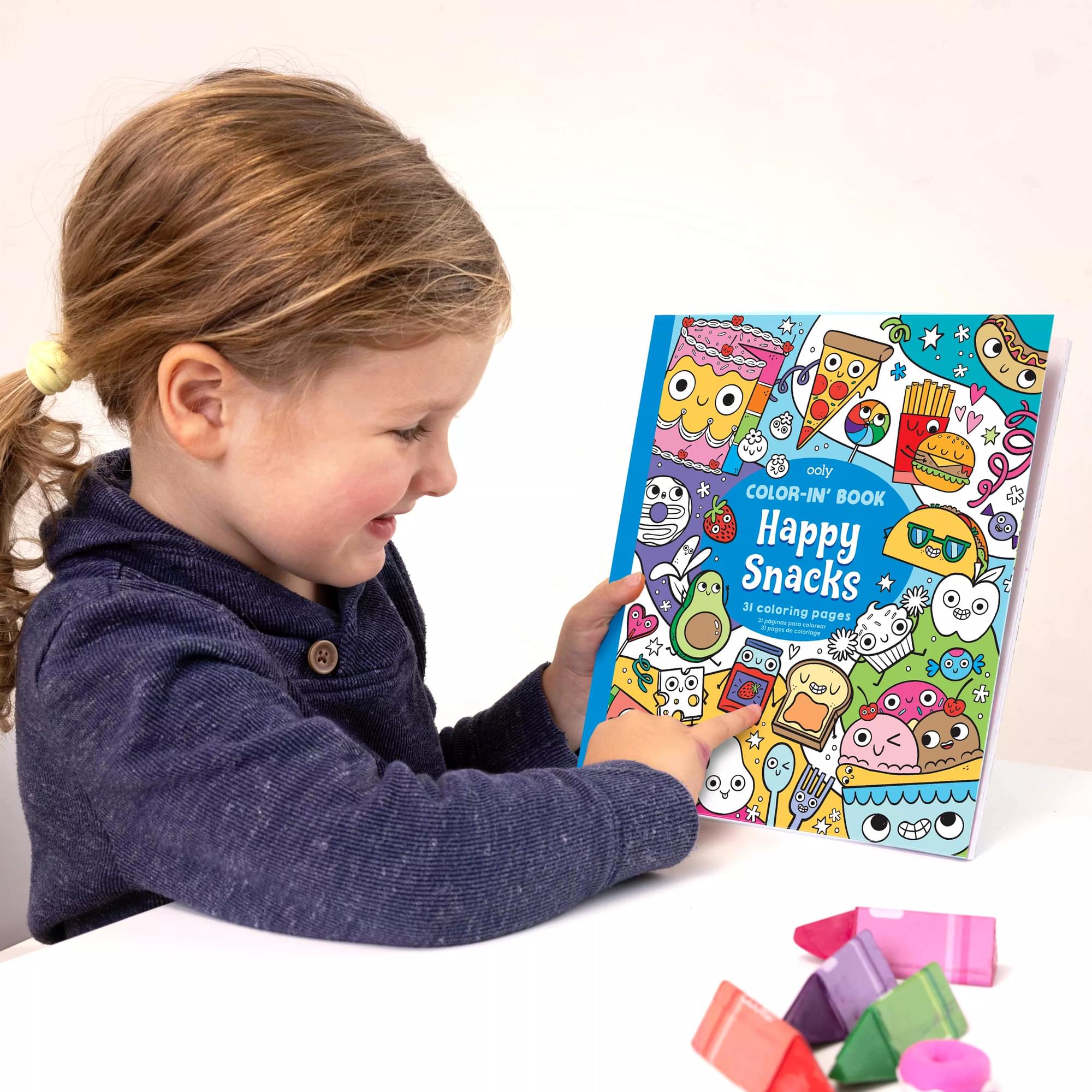 Girl pointing at OOLY Color-In Book Coloring Book Happy Snacks