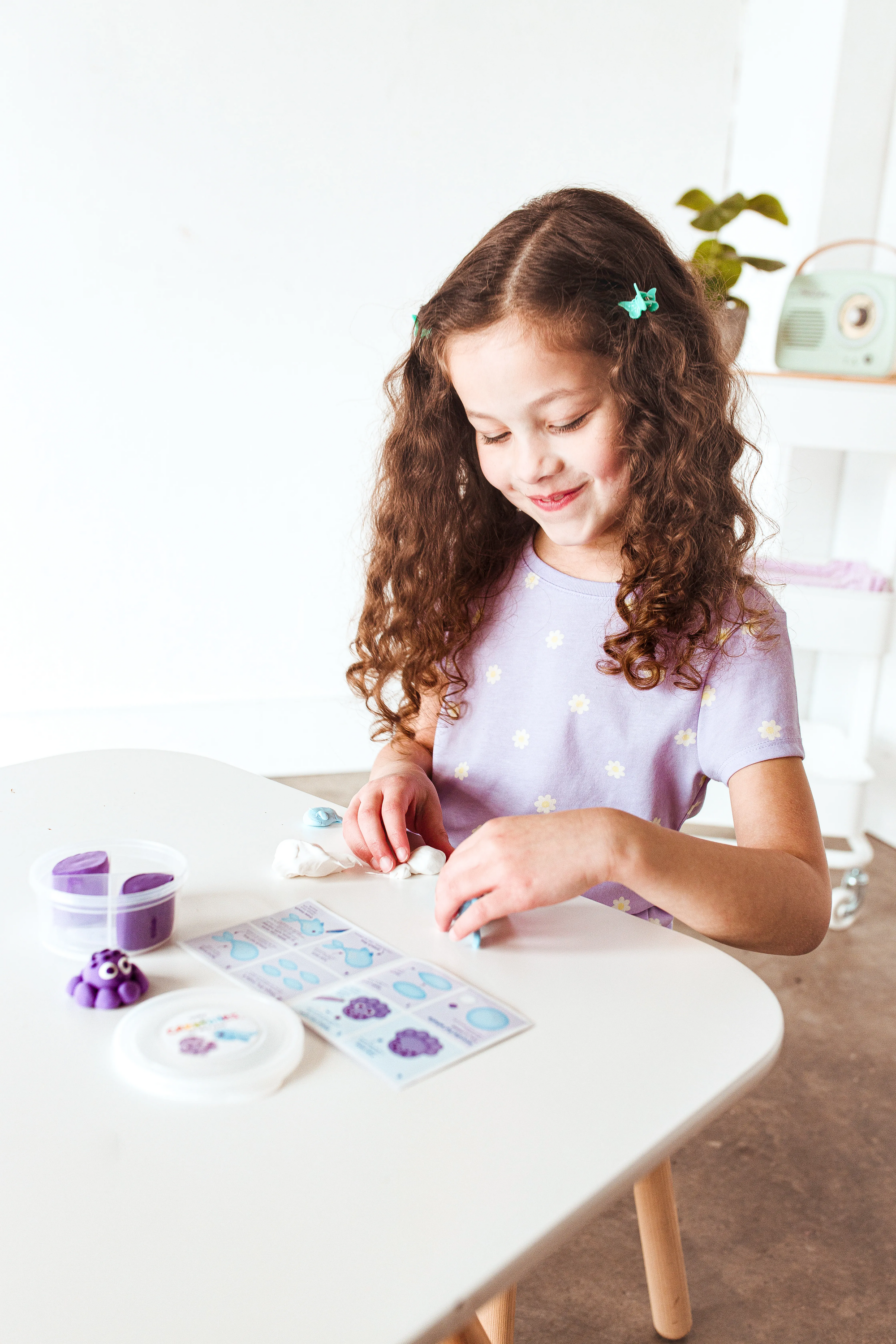 Girl building clay from OOLY Creatibles Mini Air Dry Clay Kit - Ocean BFFs
