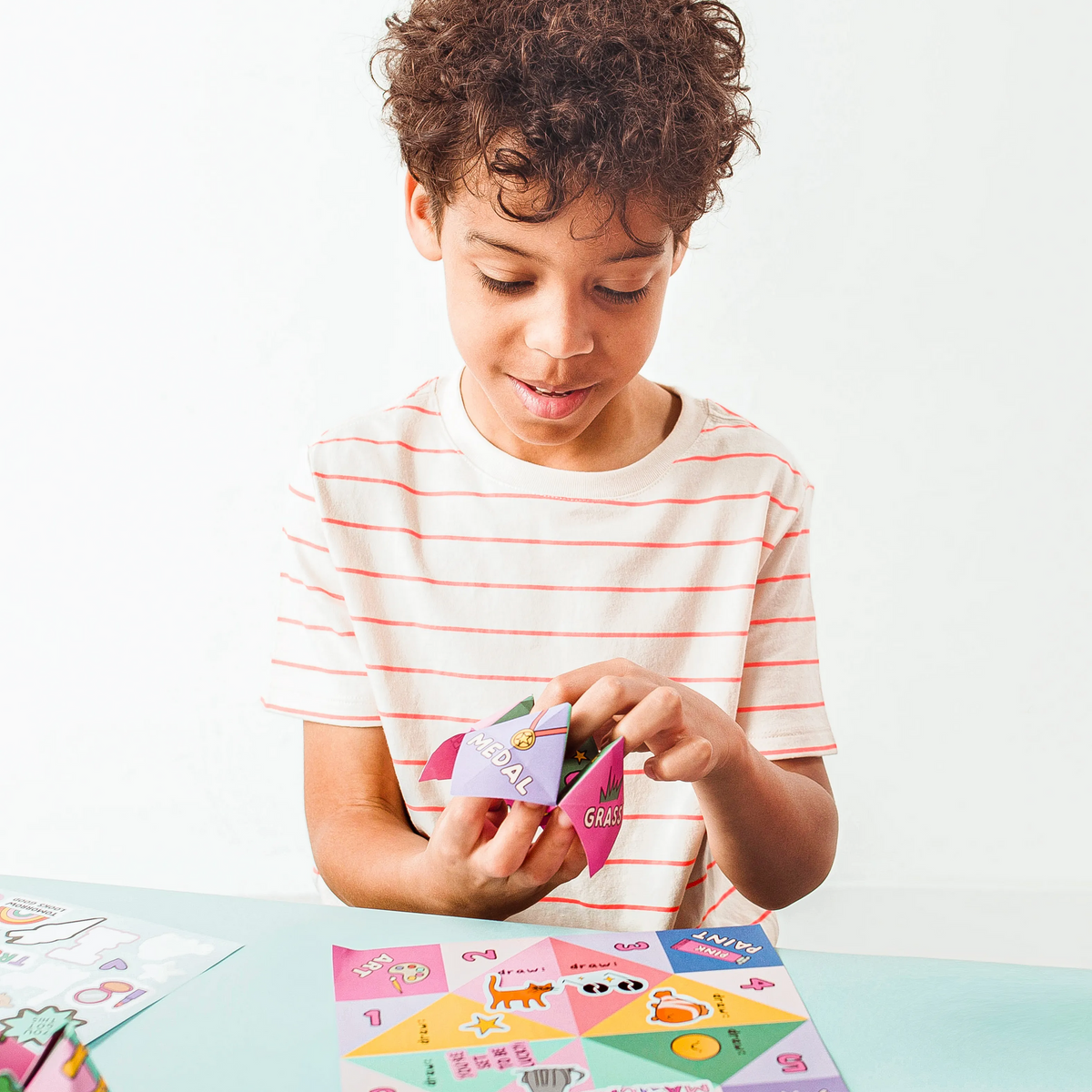 Kid playing with finished OOLY DIY Fortune Teller