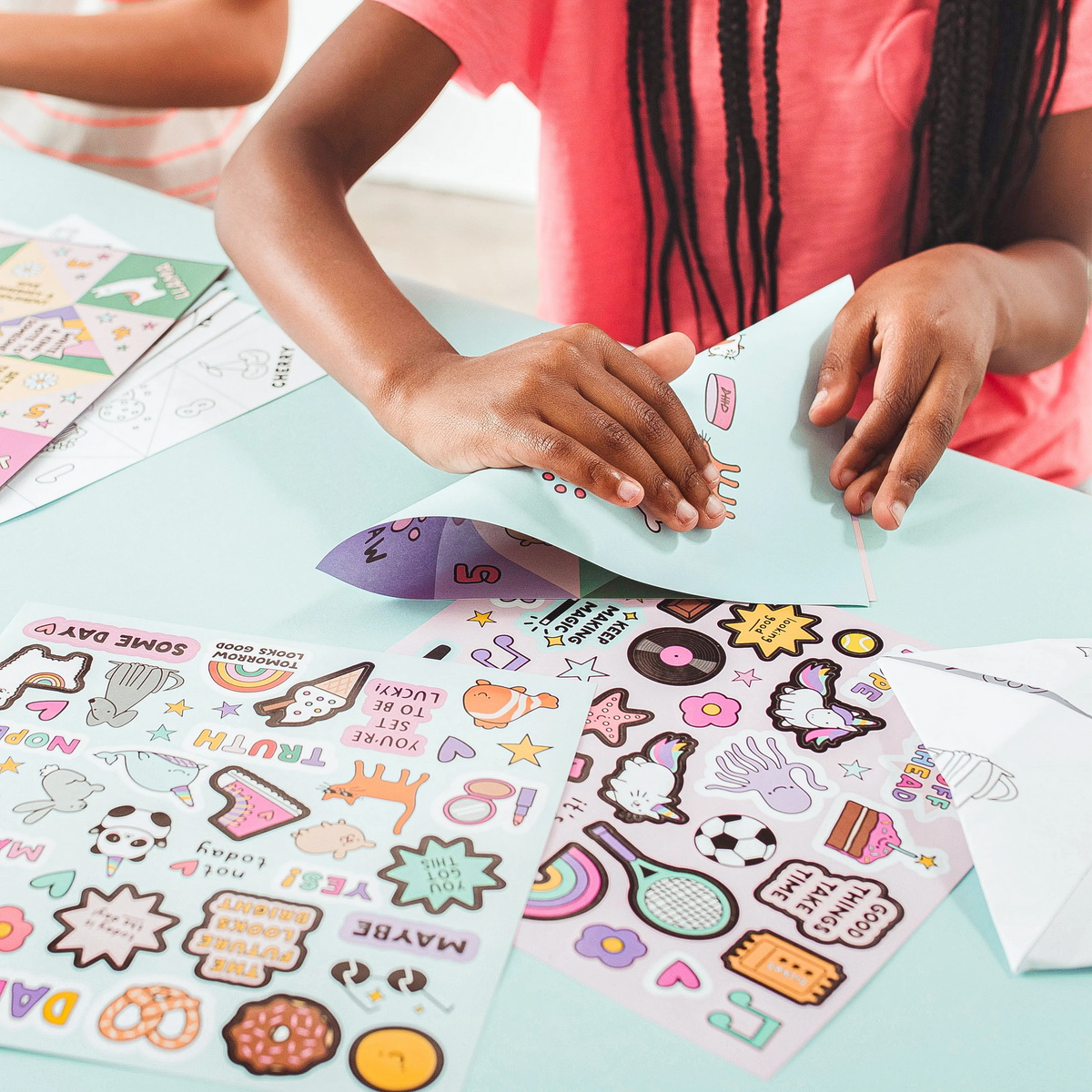 Kid folding fortune teller from OOLY DIY Fortune Tellers Activity Kit