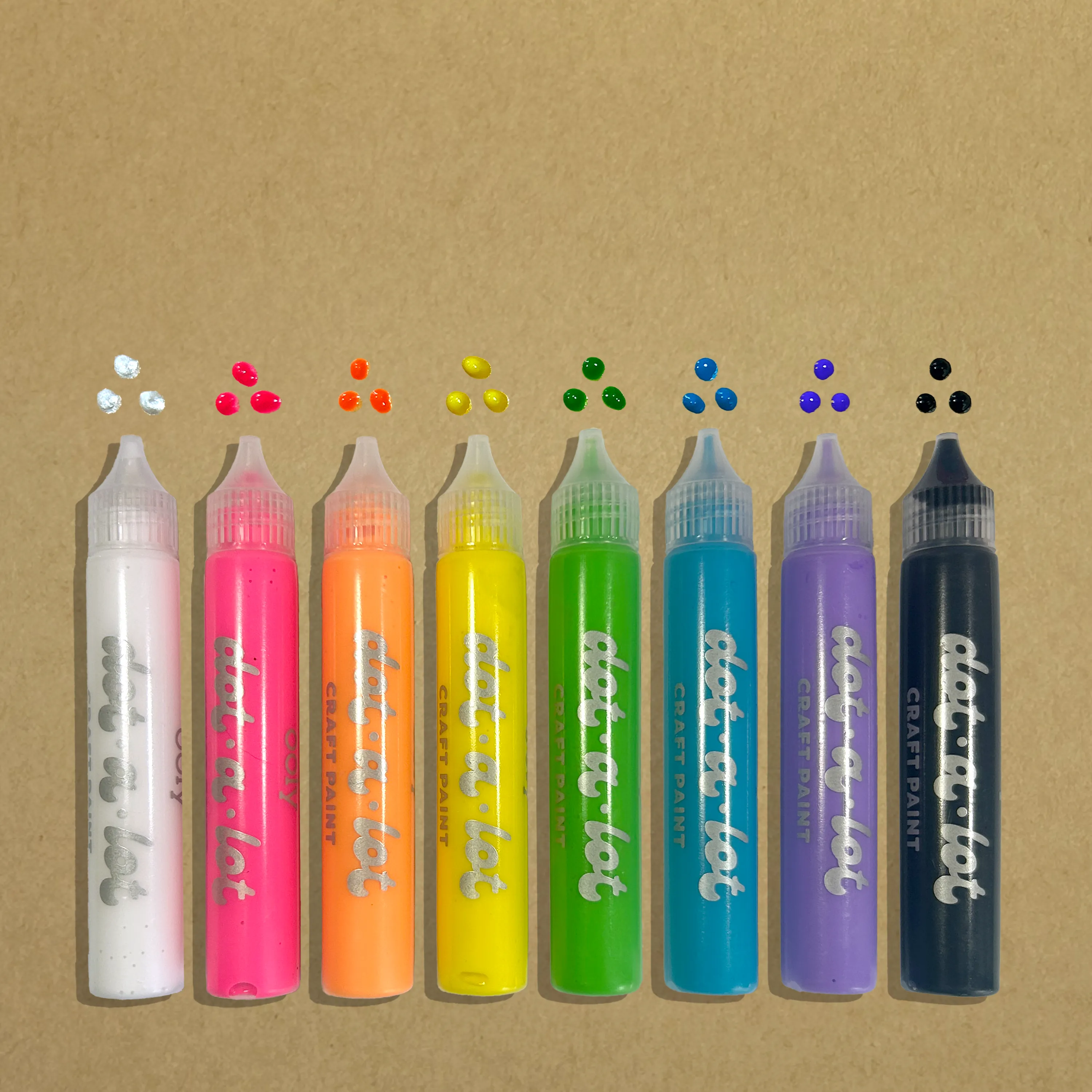 Row of eight OOLY Dot-a-Lot 3D Dimensional Craft Paint - Brights with dotted swatches on kraft paper