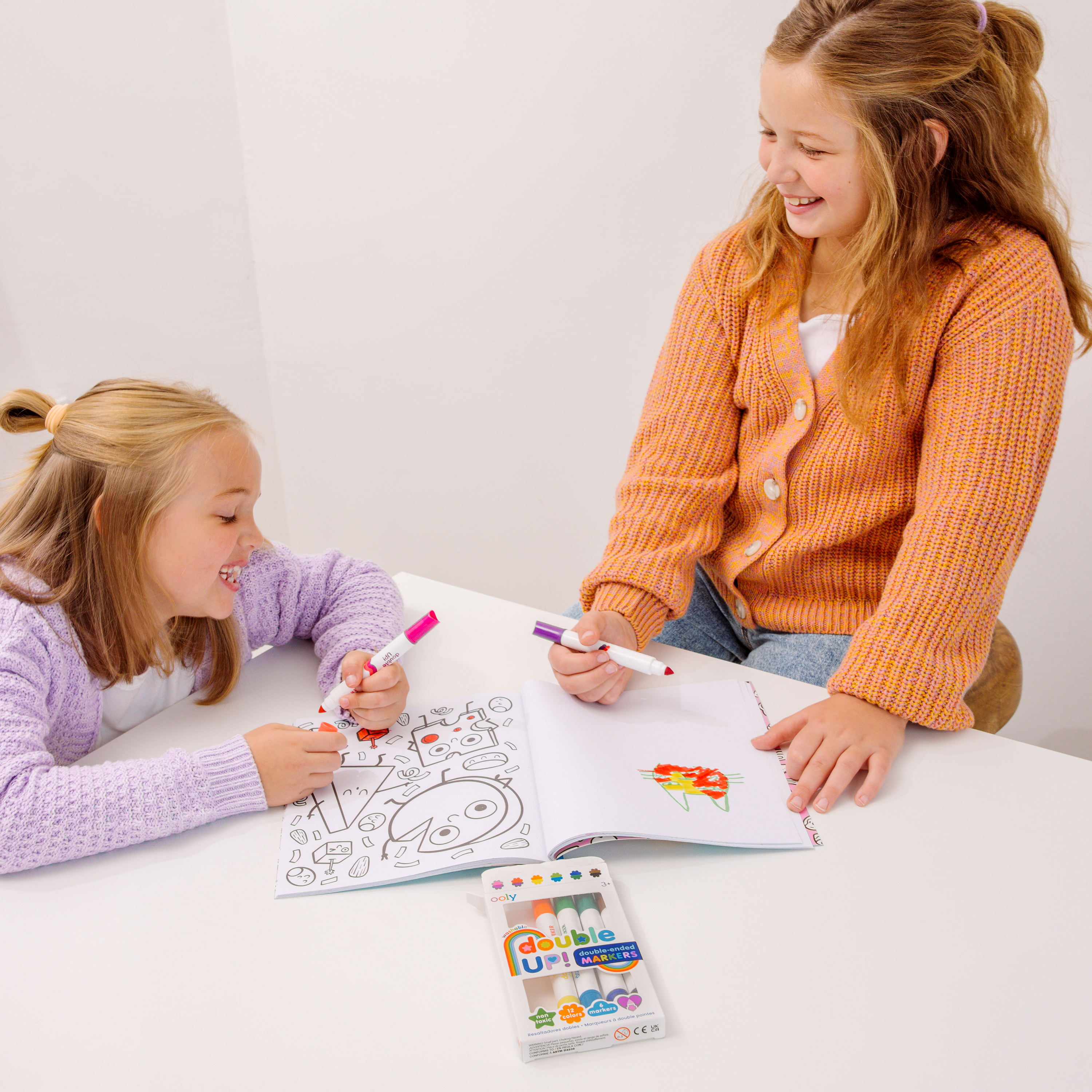 Two girls coloring with Double Up! Double-Ended Markers in a coloring book