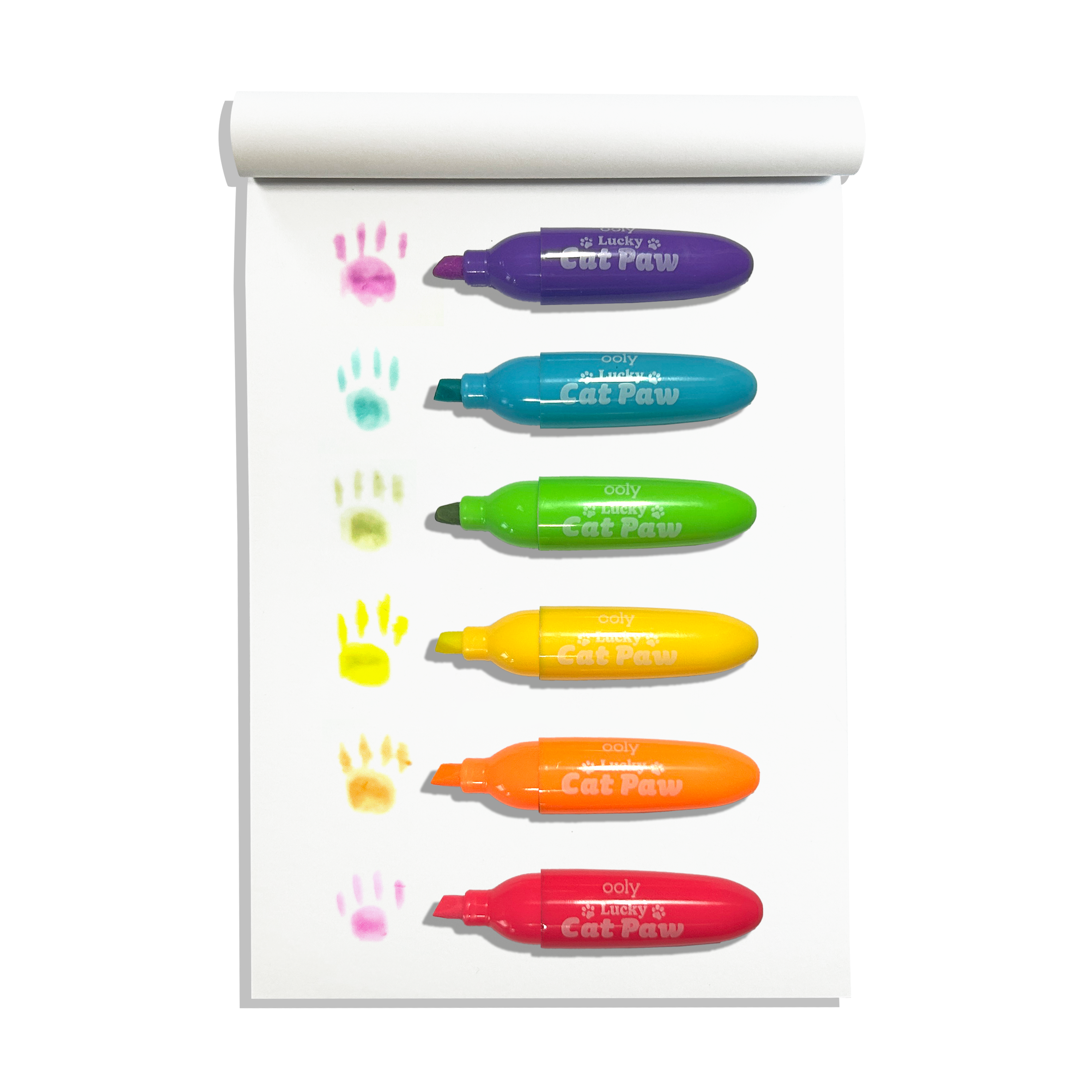 Row of uncapped OOLY Lucky Cat Paw Scented Neon Highlighters on a white sketchbook with cat paw swatches