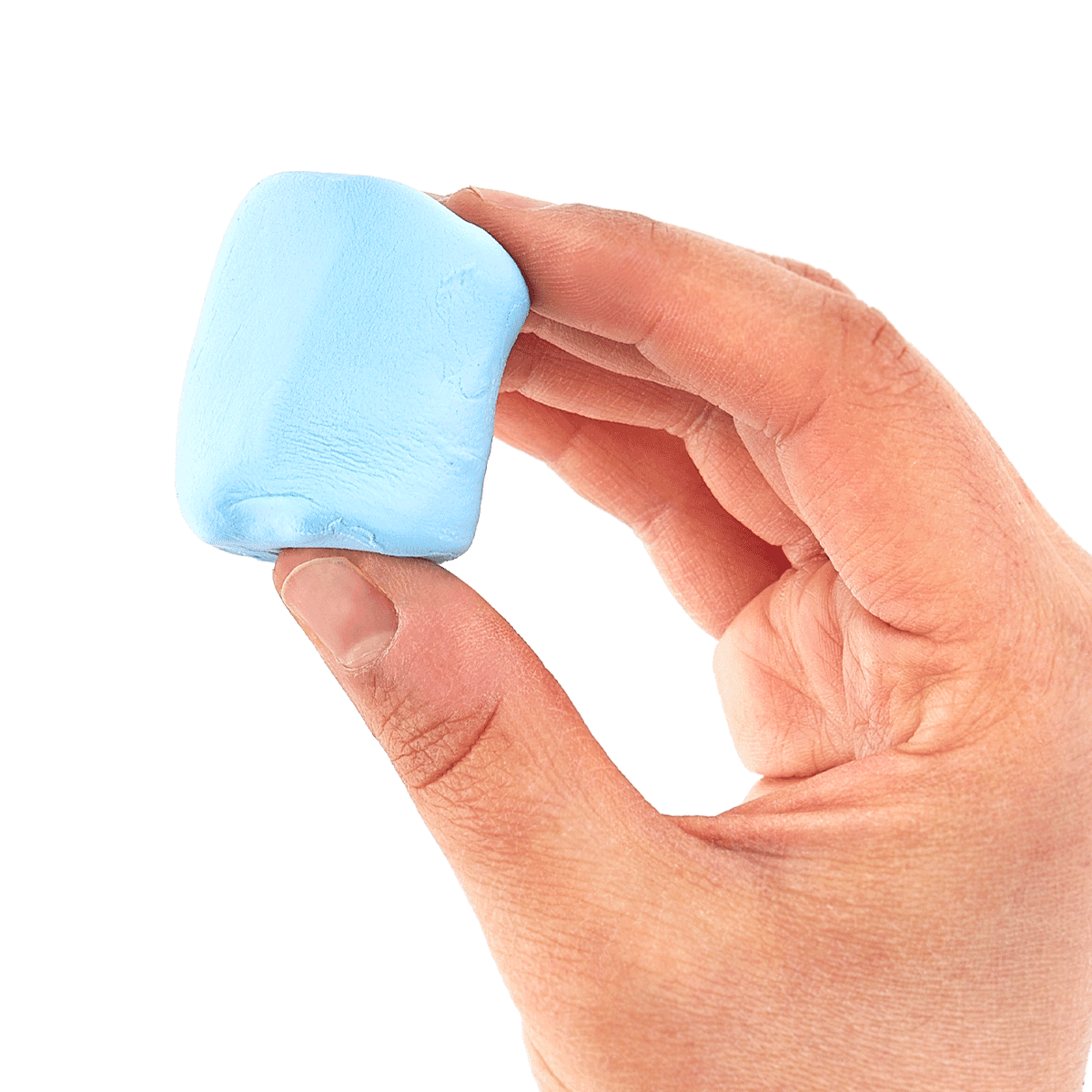 Hand holding a block of light blue clay from an OOLY Creatibles Standard Air Dry Clay Kit against a white background