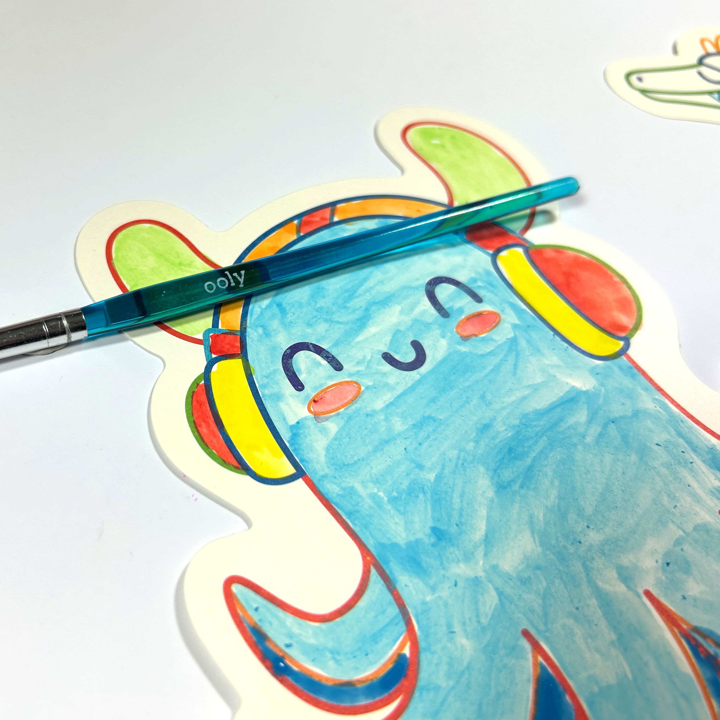 Close up of painted octopus and paintbrush from the OOLY Ocean Fun Playful Painters Easy Watercolor Painting Kit on a white background