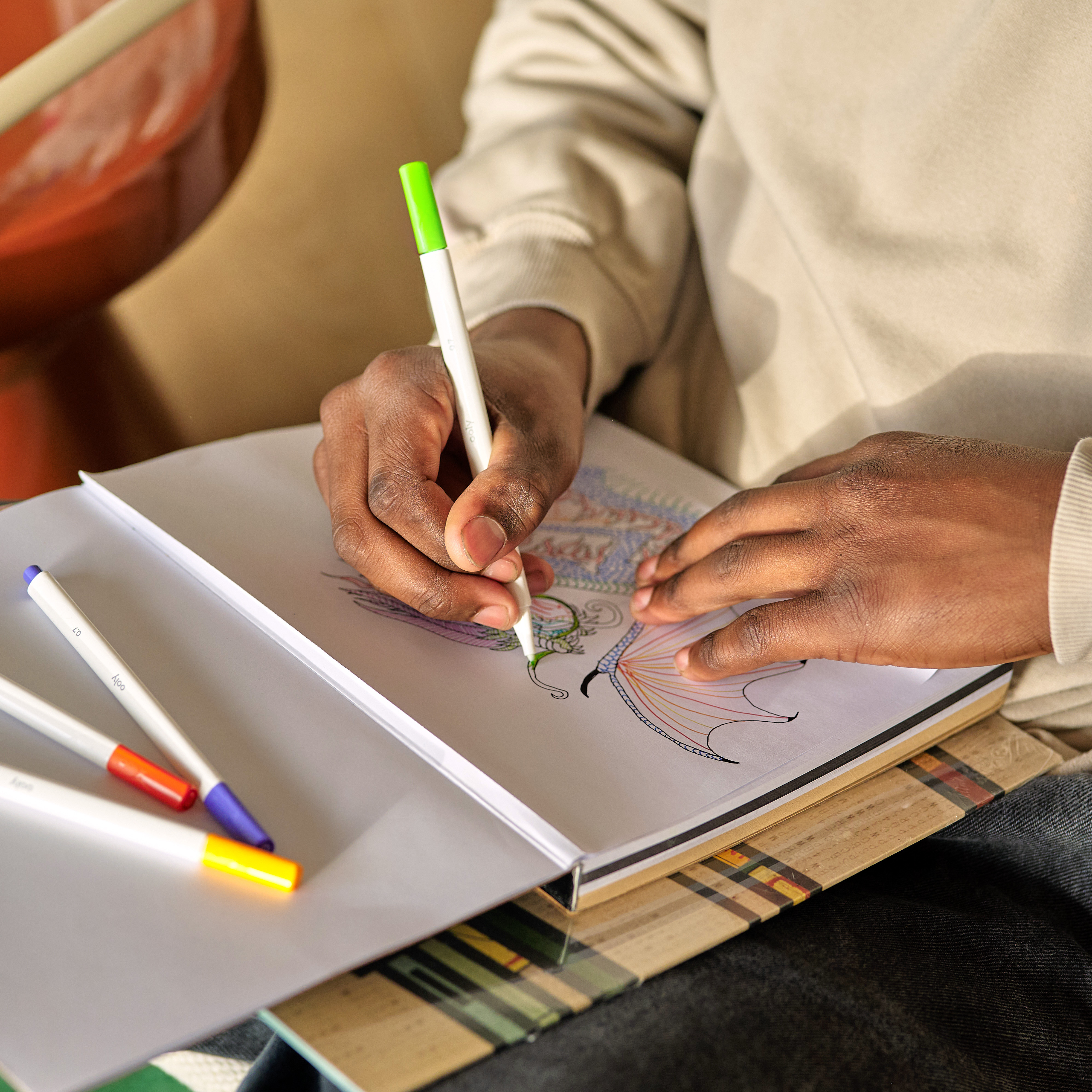 Close up of kid drawing a dragon with a set of OOLY Seriously Fine Tip Markers