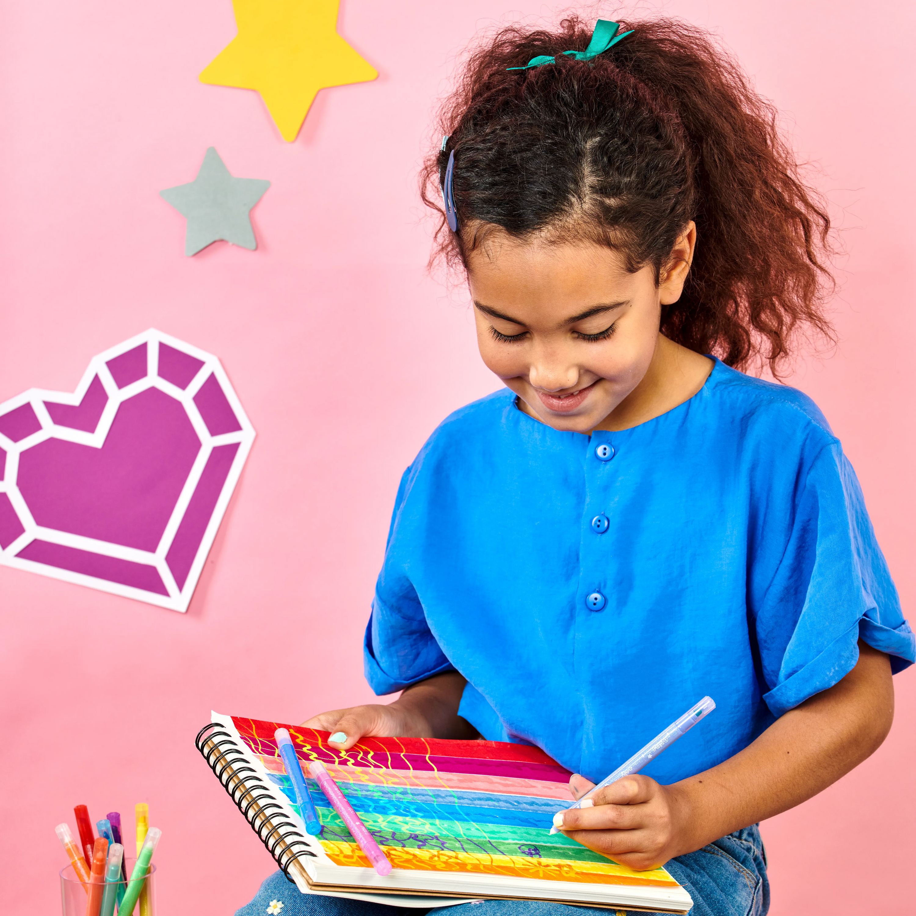 Girl color changing colored swatches on sketchbook using OOLY Switch-Eroo Sparkle Glittery Color Changing Markers