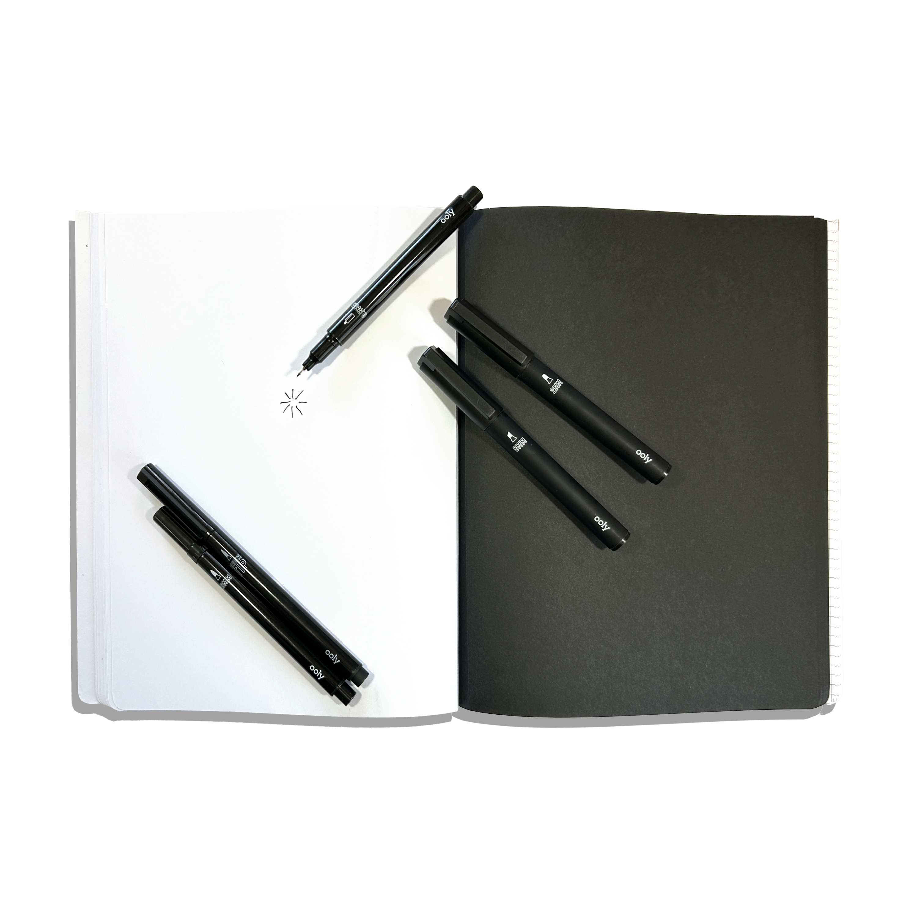 White and black paper pages in an opened OOLY's The Paper Works Sketchbook on a white background