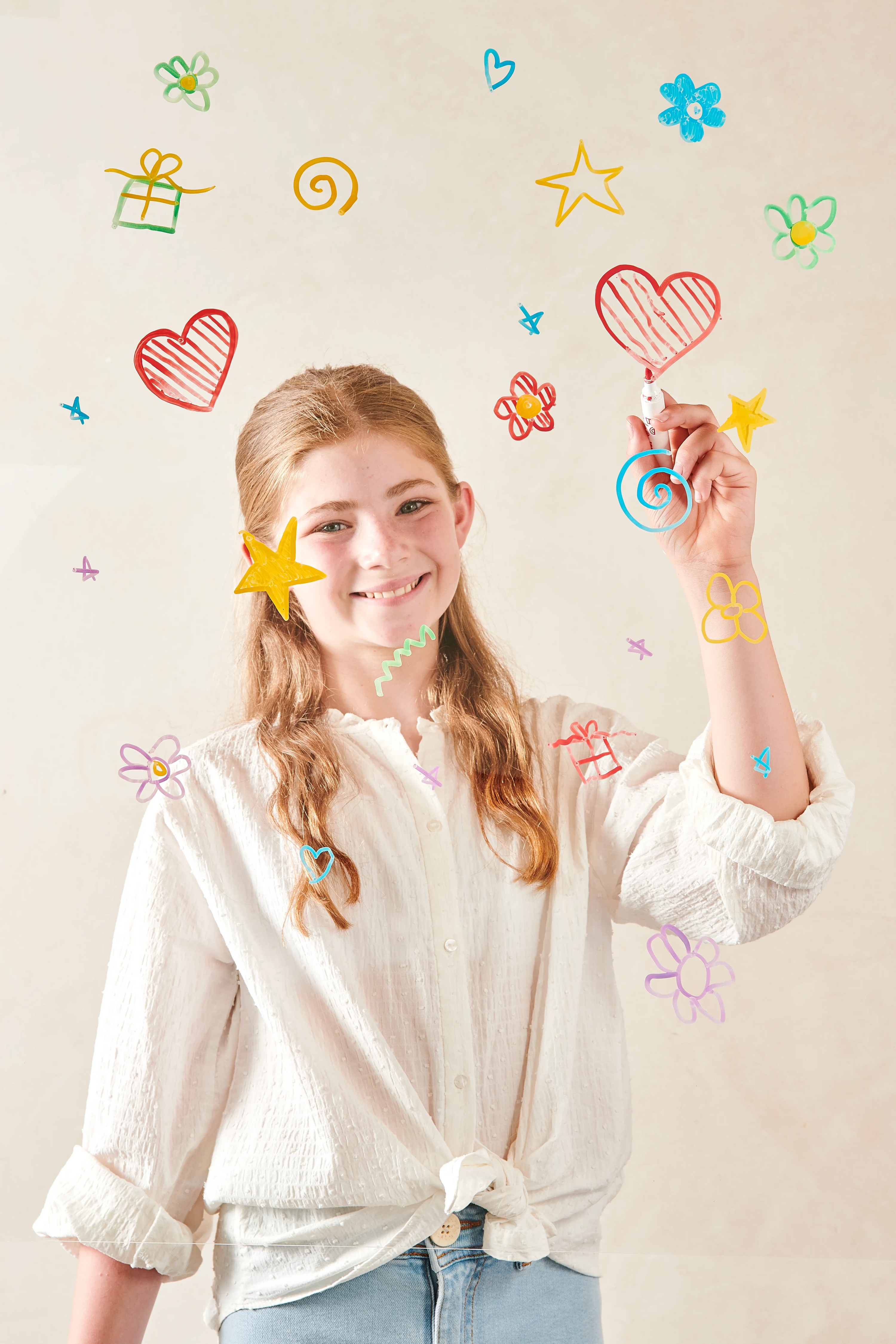 Girl coloring hearts, stars and flowers with OOLY Vivid Pop! Water Based Paint Markers