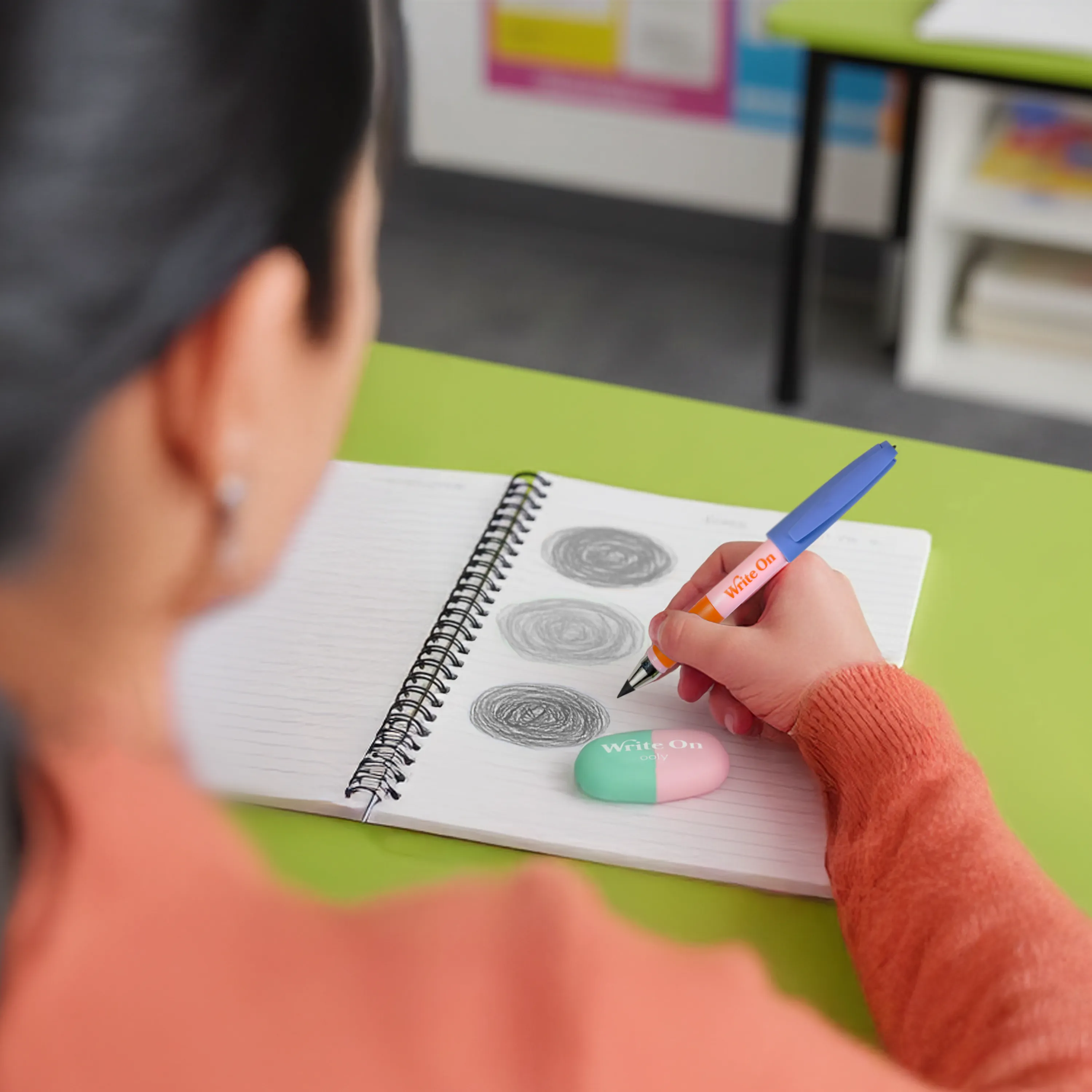 Woman drawing various circles in a notepad with OOLY Write On Graphite Pencils