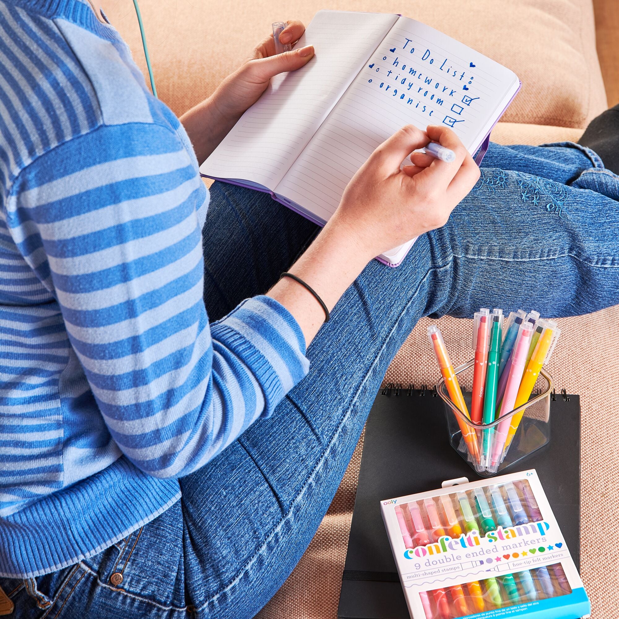 Girl creating to-do list with set of OOLY Confetti Stamp Double-Ended Markers close up