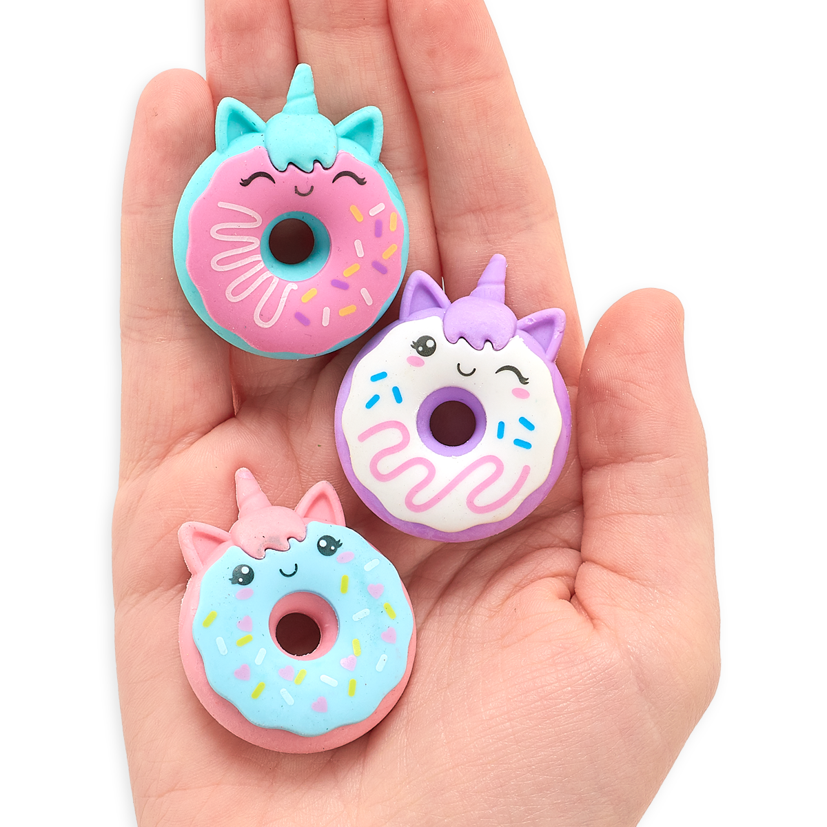 Hand holding all three Magic Bakery Unicorn Donut Erasers in its palm