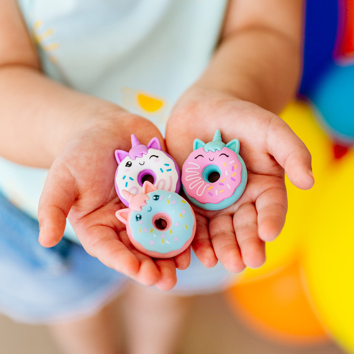 Girl holding OOLY Unicorn Donut Scented Erasers in her hands