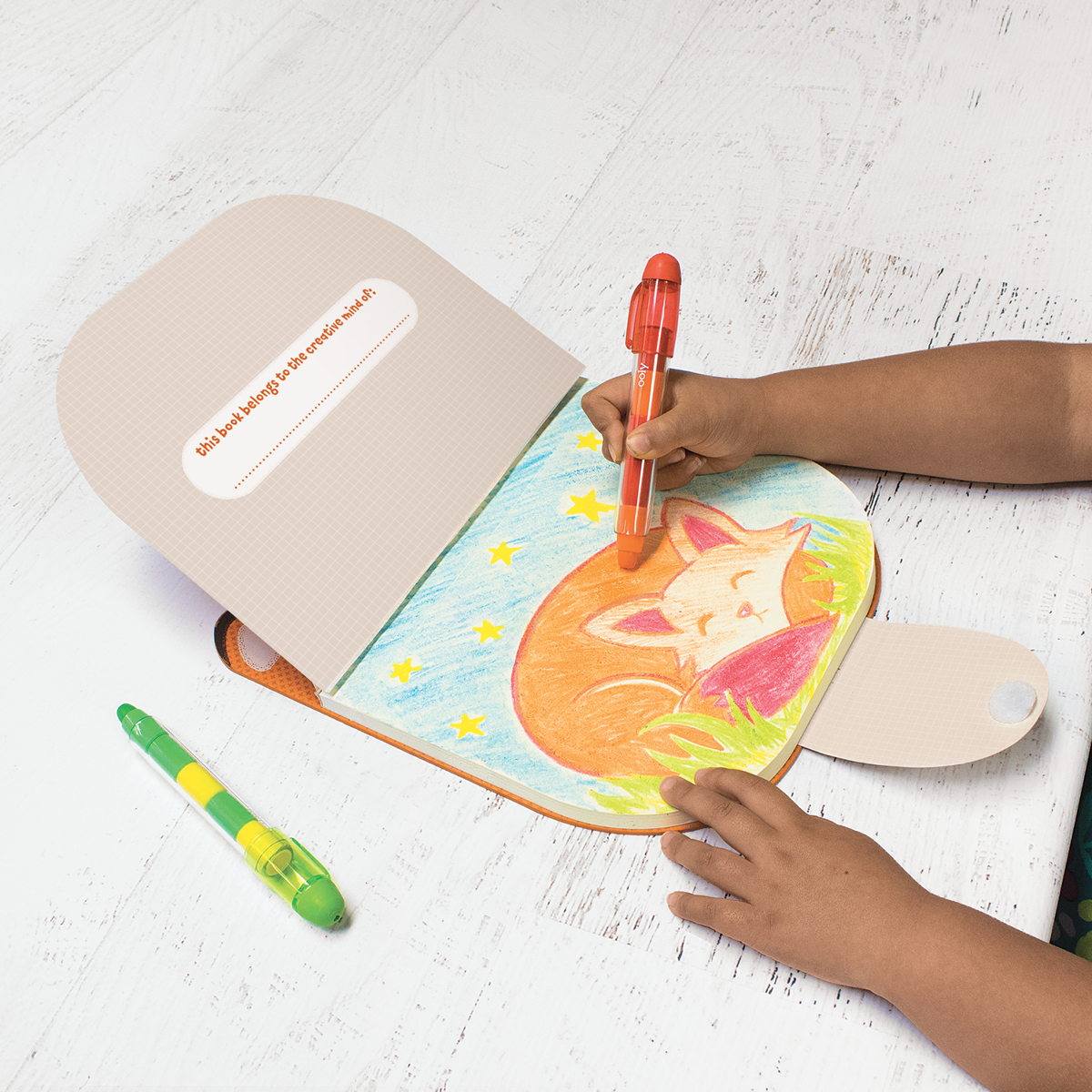 Child drawing in fox sketchbook