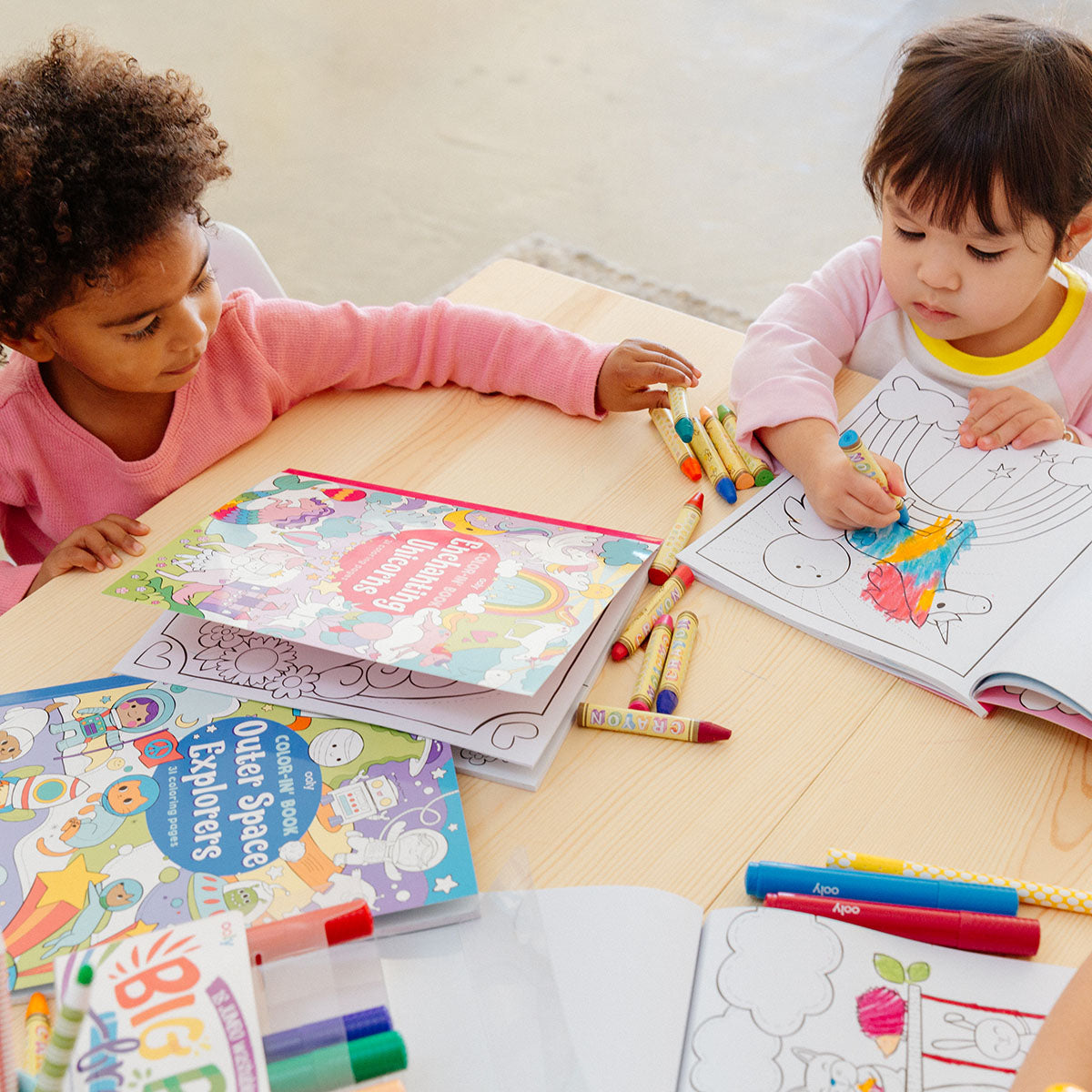 2 kids coloring in an Enchanting Unicorns Coloring Book
