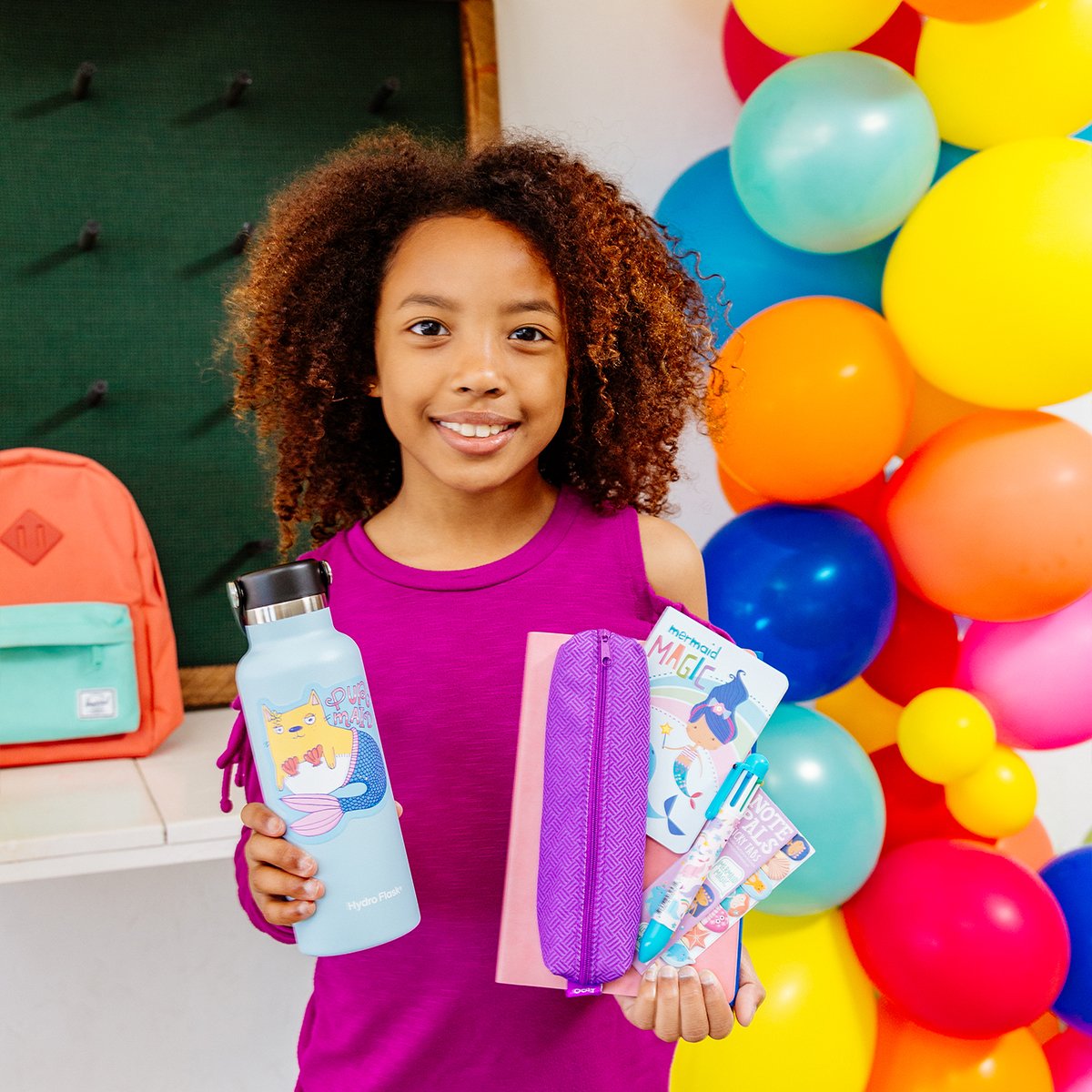 Girl holding water bottle with Mer-Made to Party sticker on it