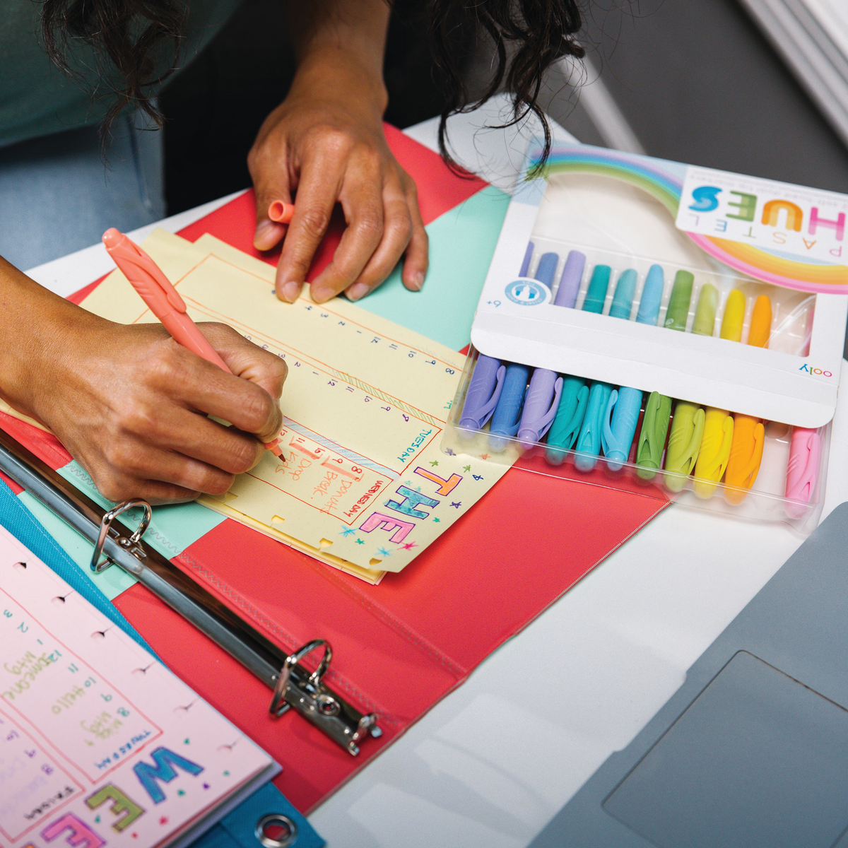 Woman writing in planner with Pastel Hues Markers