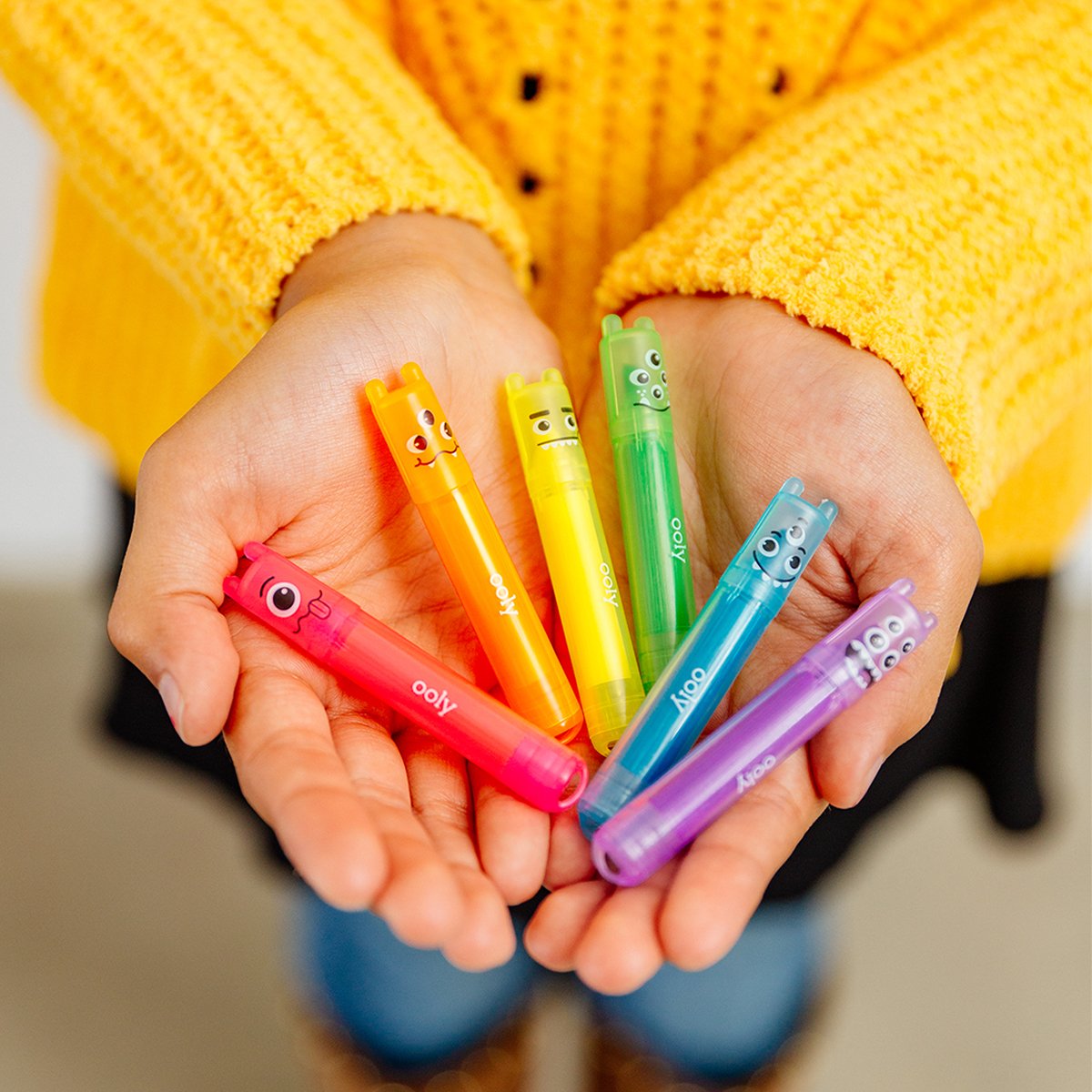 Image of hands holding fanned out Mini Monster Markers up