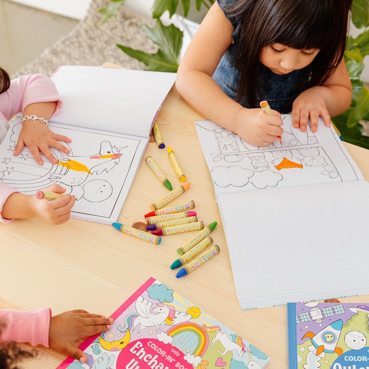 Kids coloring in coloring books with Brilliant Bee Crayons on the table