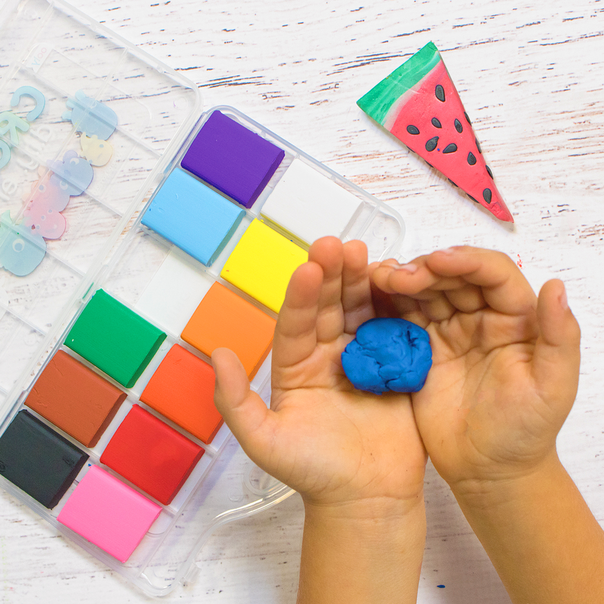 Kid holding blue Creatibles DIY eraser clay