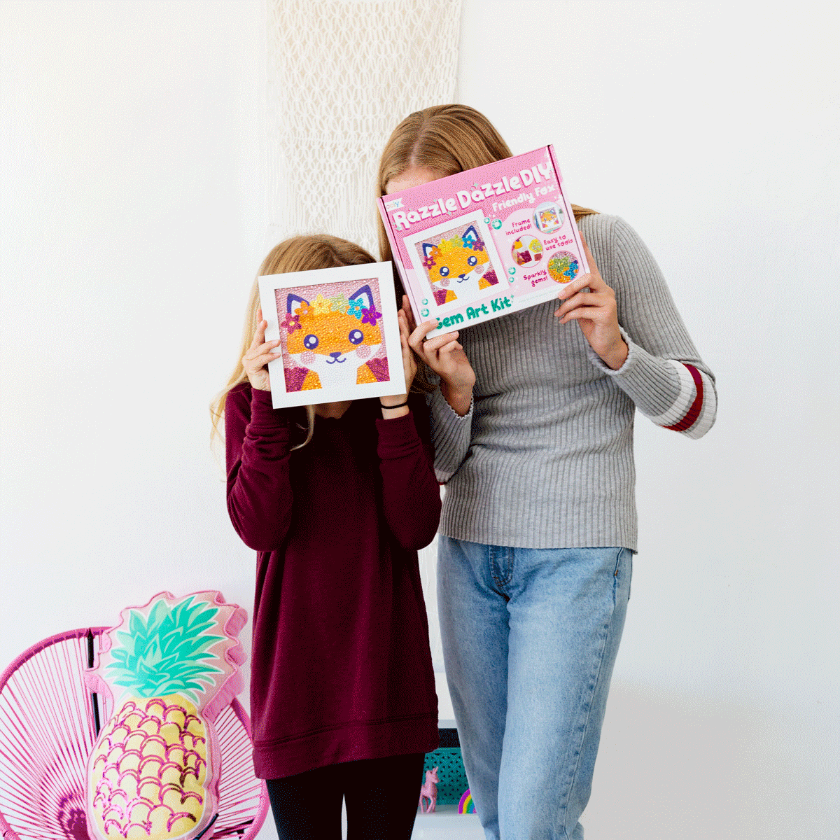 Gif of girls peeking out from behind finished friendly fox razzle dazzle art and packaging