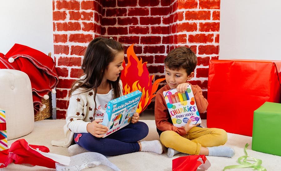 Kids opening their holiday gifts on Christmas morning, chunkies paint sticks and razzle dazzle DIY gem art kit