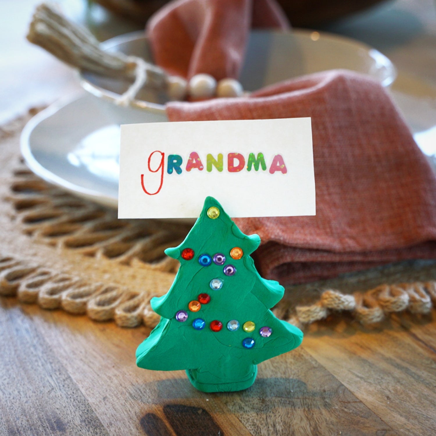 Christmas tree with gems holding grandma name card on tables with dinner settings