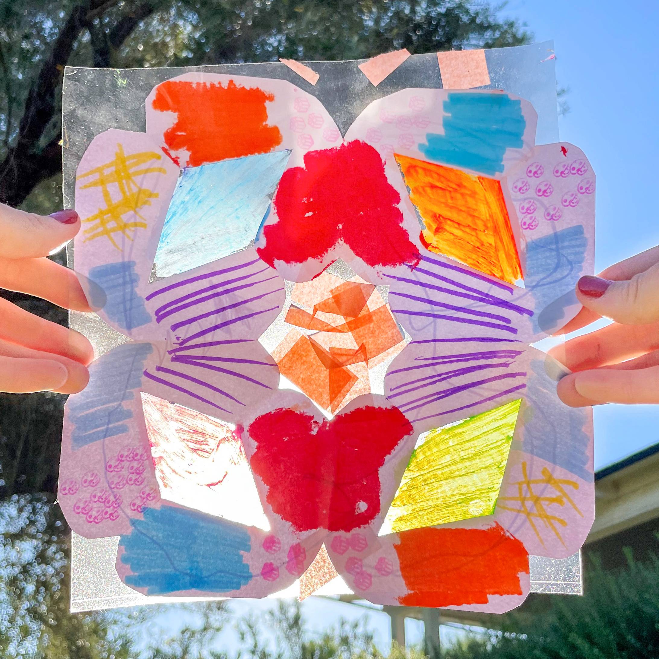 Snowflake suncatcher being held in front of the sun
