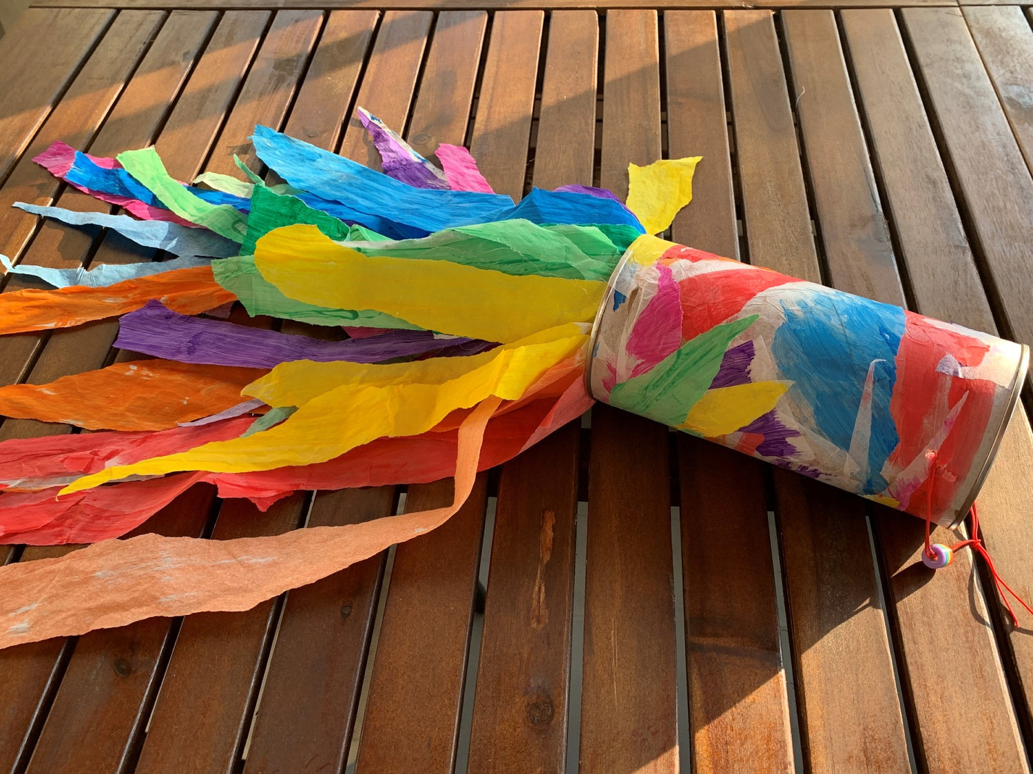 Rainbow Windsock made from tissues and a paper roll on an outdoor table