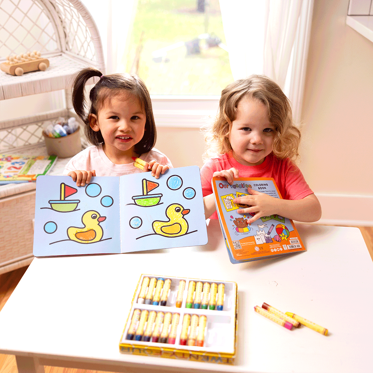 Two kids coloring with Our Day copy coloring book