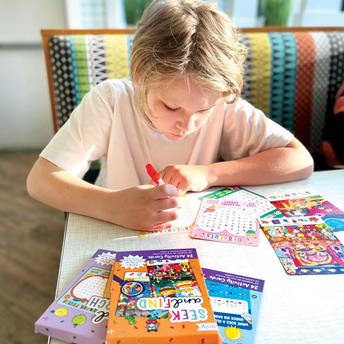 Kid playing with Paper Games activity card set