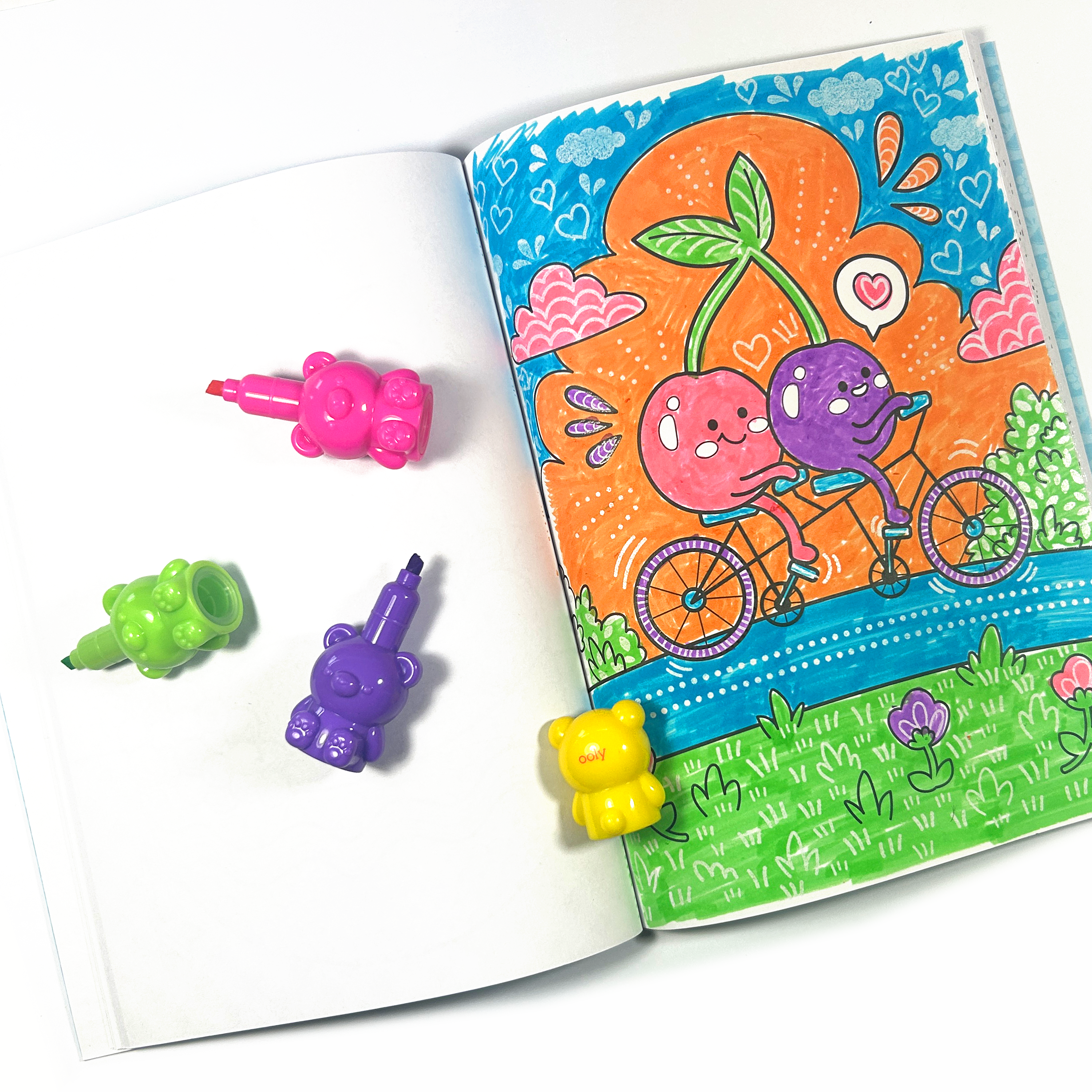 Open coloring book with cherries riding a bicycle colored with OOLY Bear Besties Stacking Highlighters