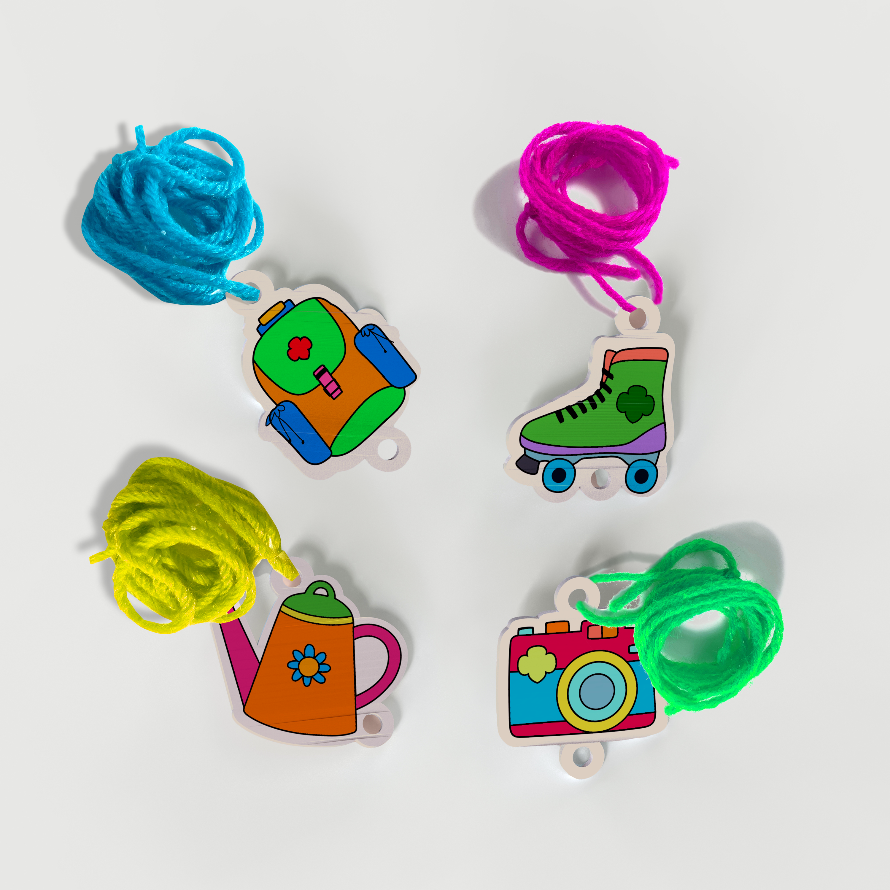 Completed shrink charm bracelets with colorful cords from the OOLY x Girl Scouts DIY Shrink Art Bracelet Kit