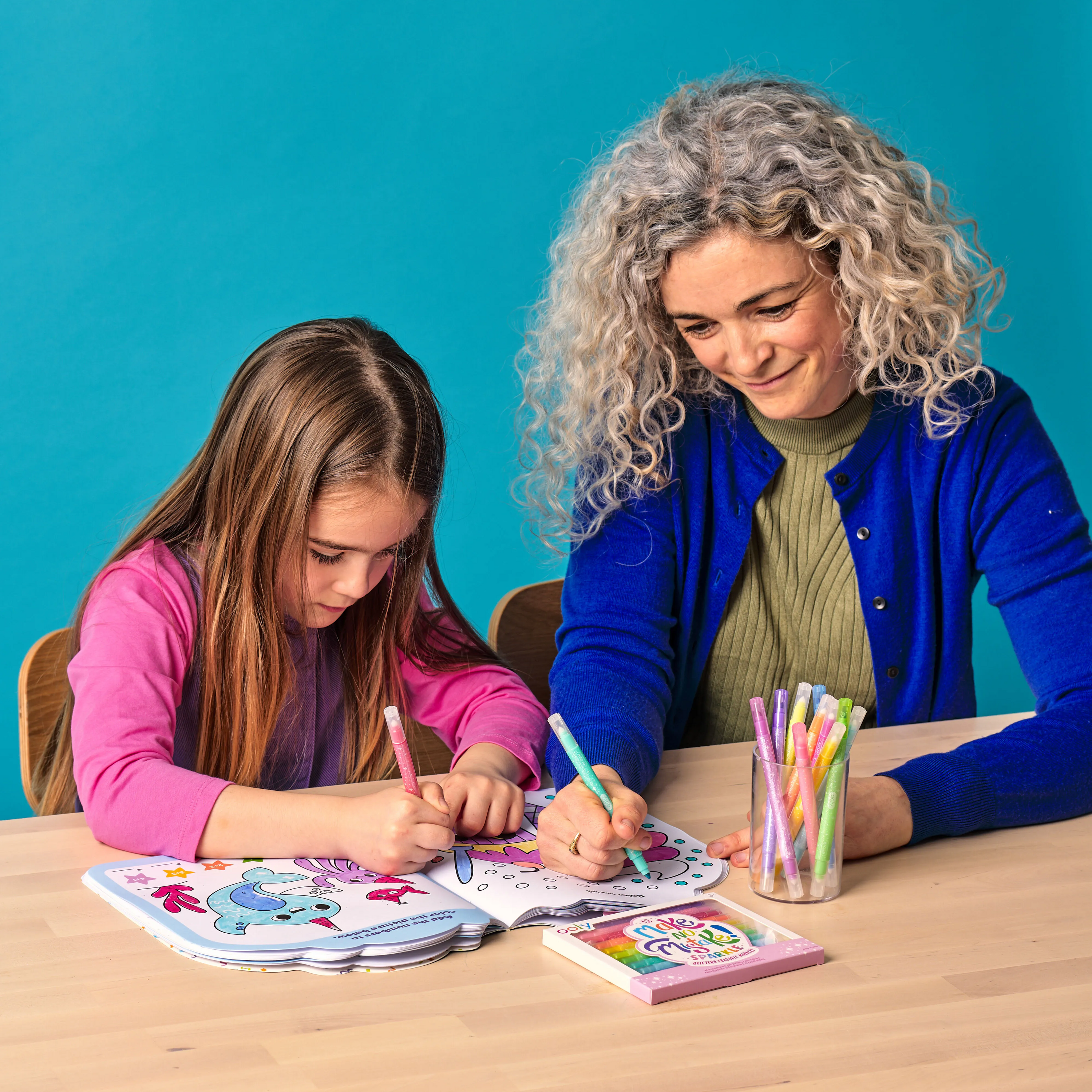 Girl and lady coloring in a coloring book with OOLY Make No Mistake! Glittery Erasable Markers
