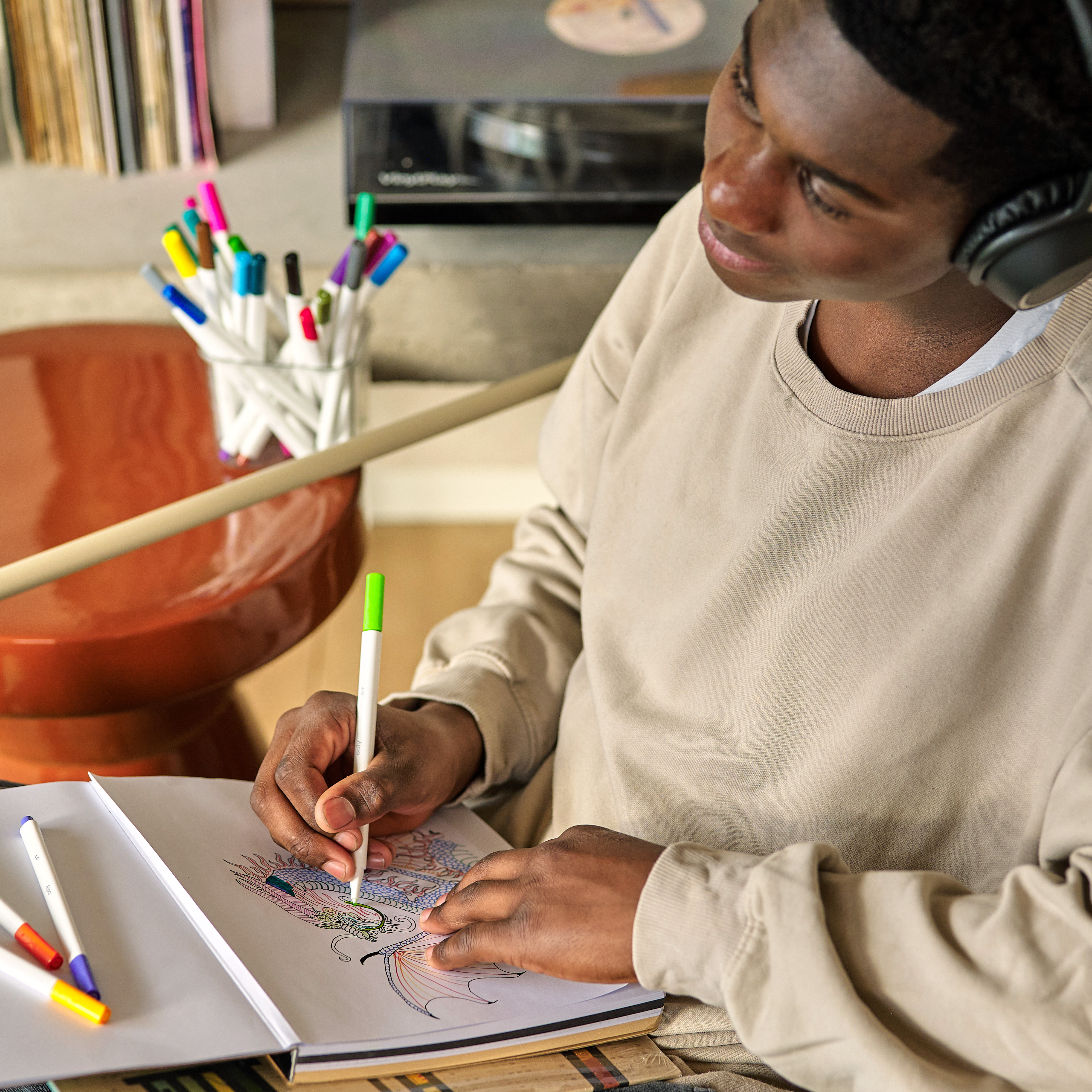 Kid drawing a dragon with a set of OOLY Seriously Fine Tip Markers