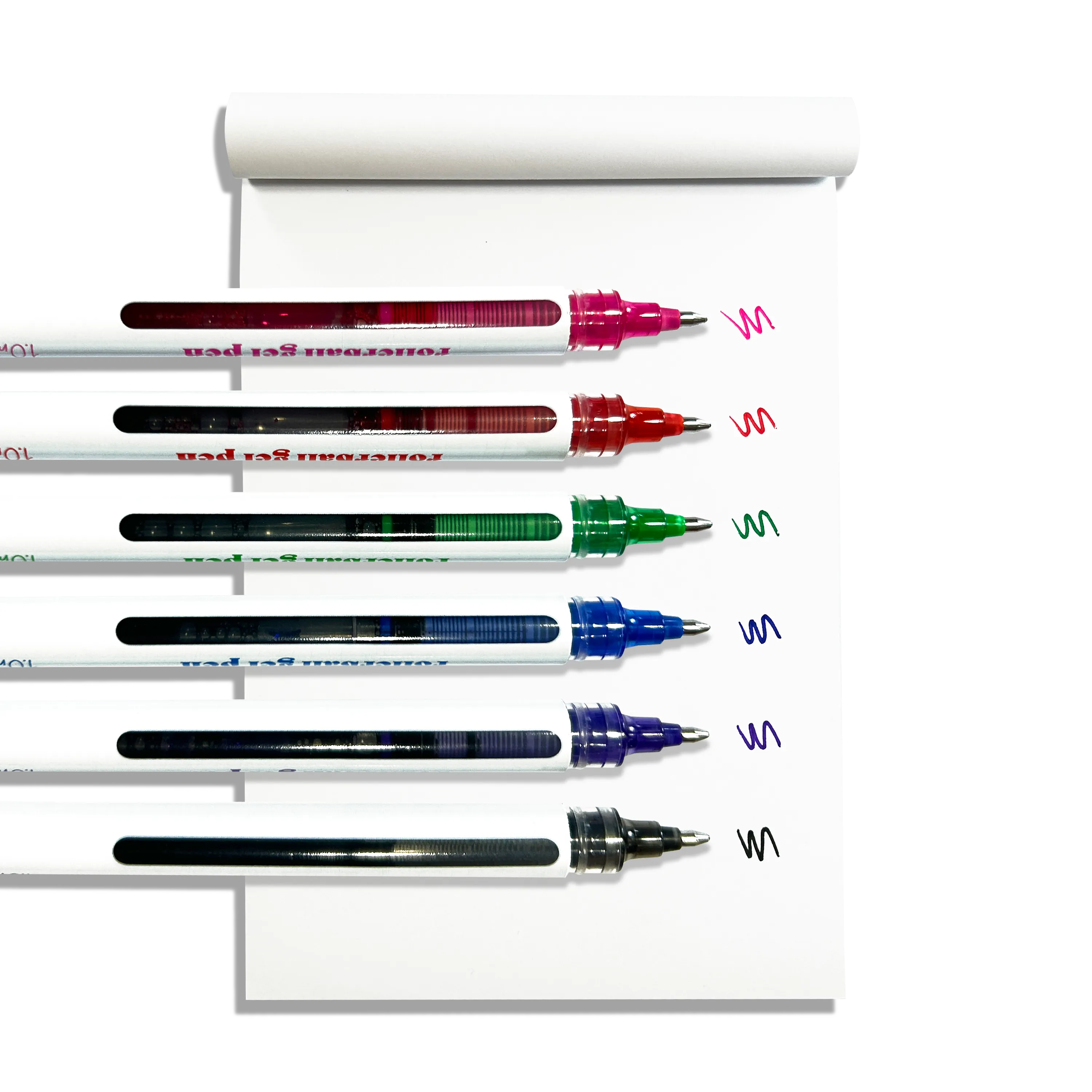 Row of uncapped OOLY Seriously Smooth Rollerball Gel Pens with color swatches on a white notepad on a white background