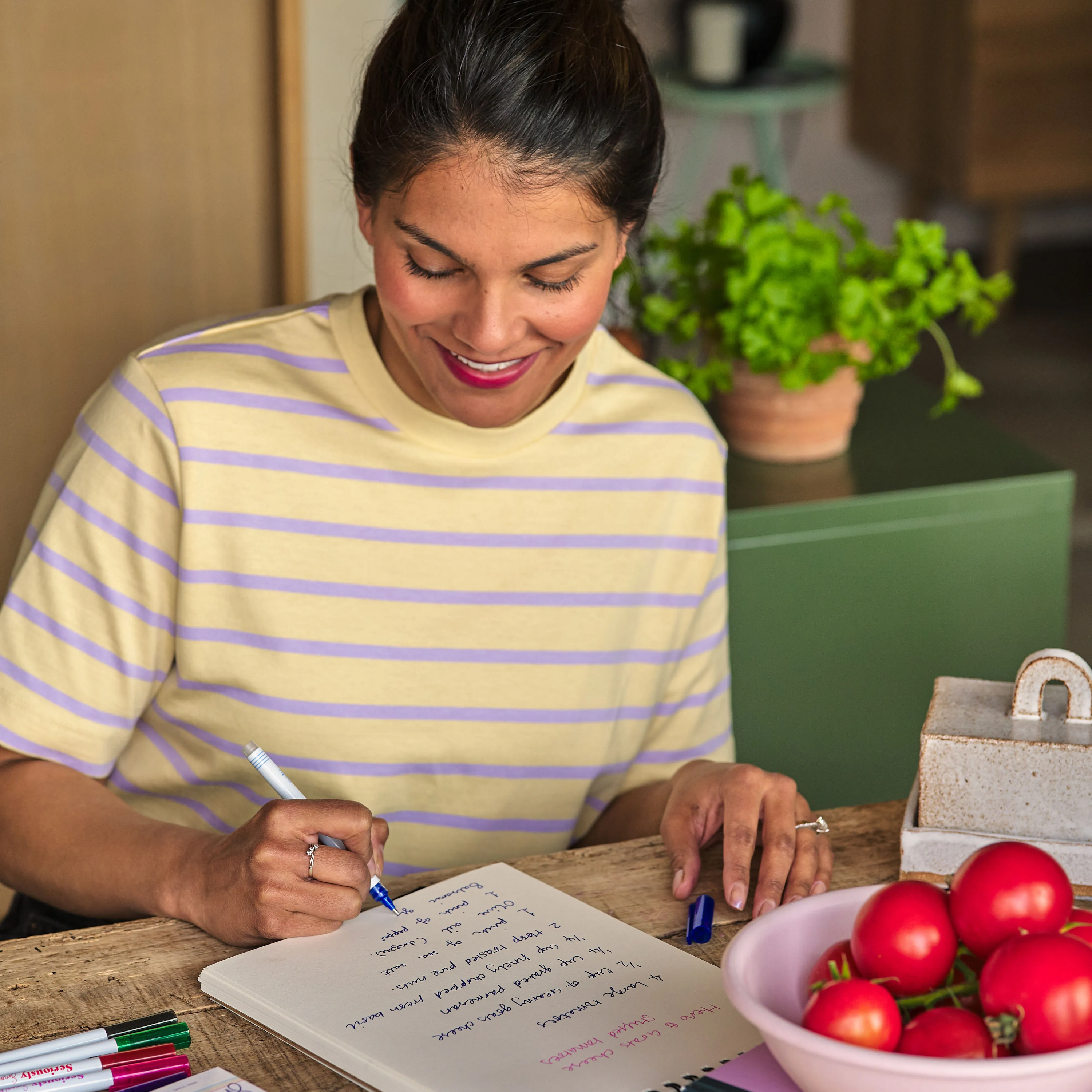 Woman writing in a white sketchbook with OOLY Seriously Smooth Rollerball Gel Pens