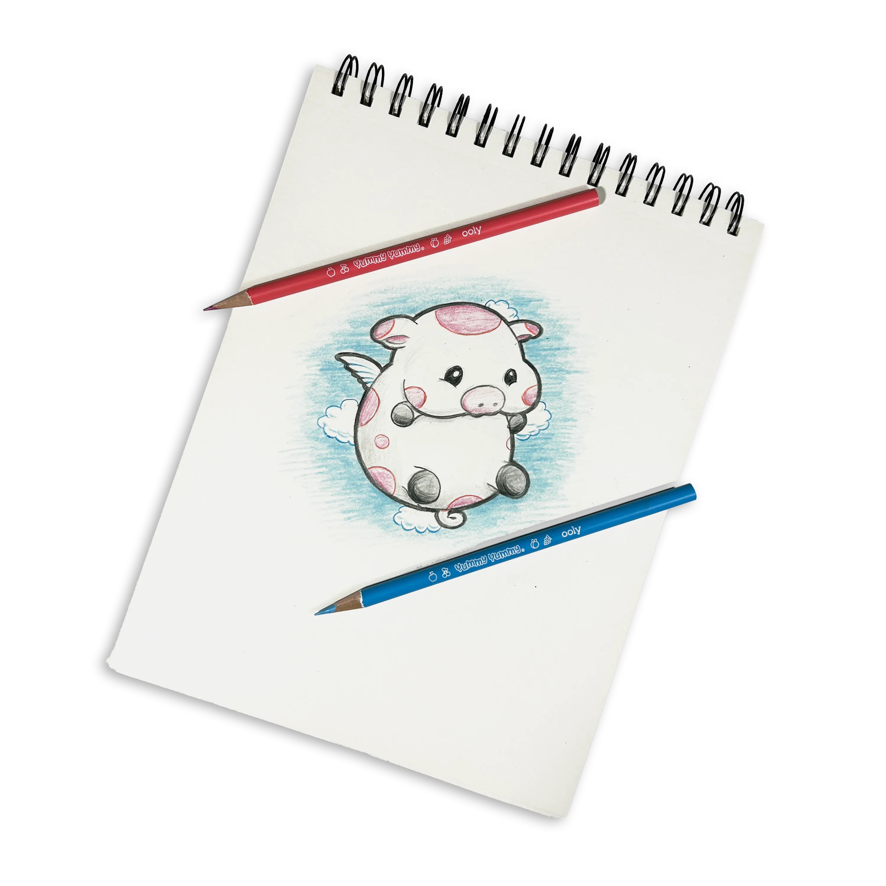 White sketchbook with colored drawing of cute cow with wings made with OOLY Yummy Yummy Fruit Scented Colored Pencils