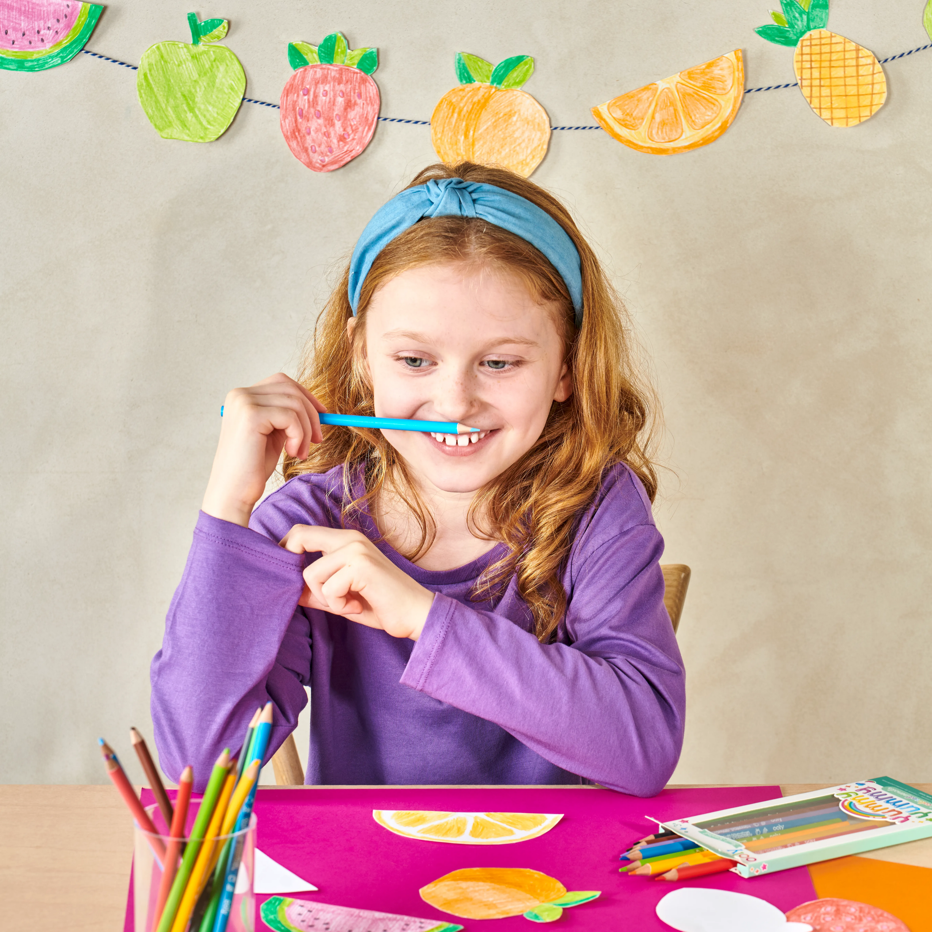 Girl at table smelling blue OOLY Yummy Yummy Fruit Scented Colored Pencil