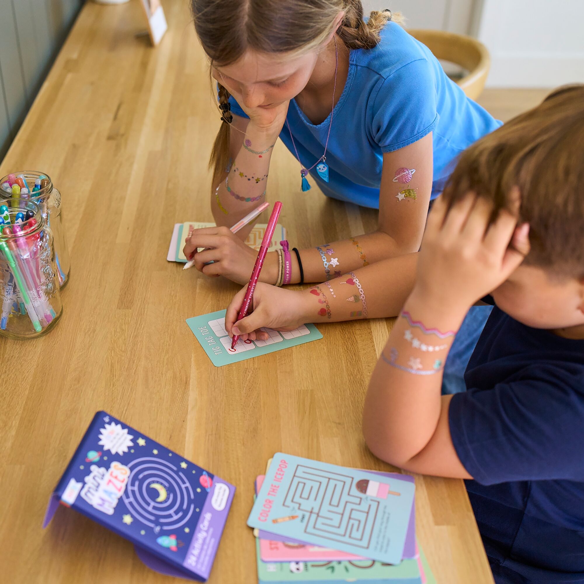 Kids playing OOLY Mini Mazes activity kit on table